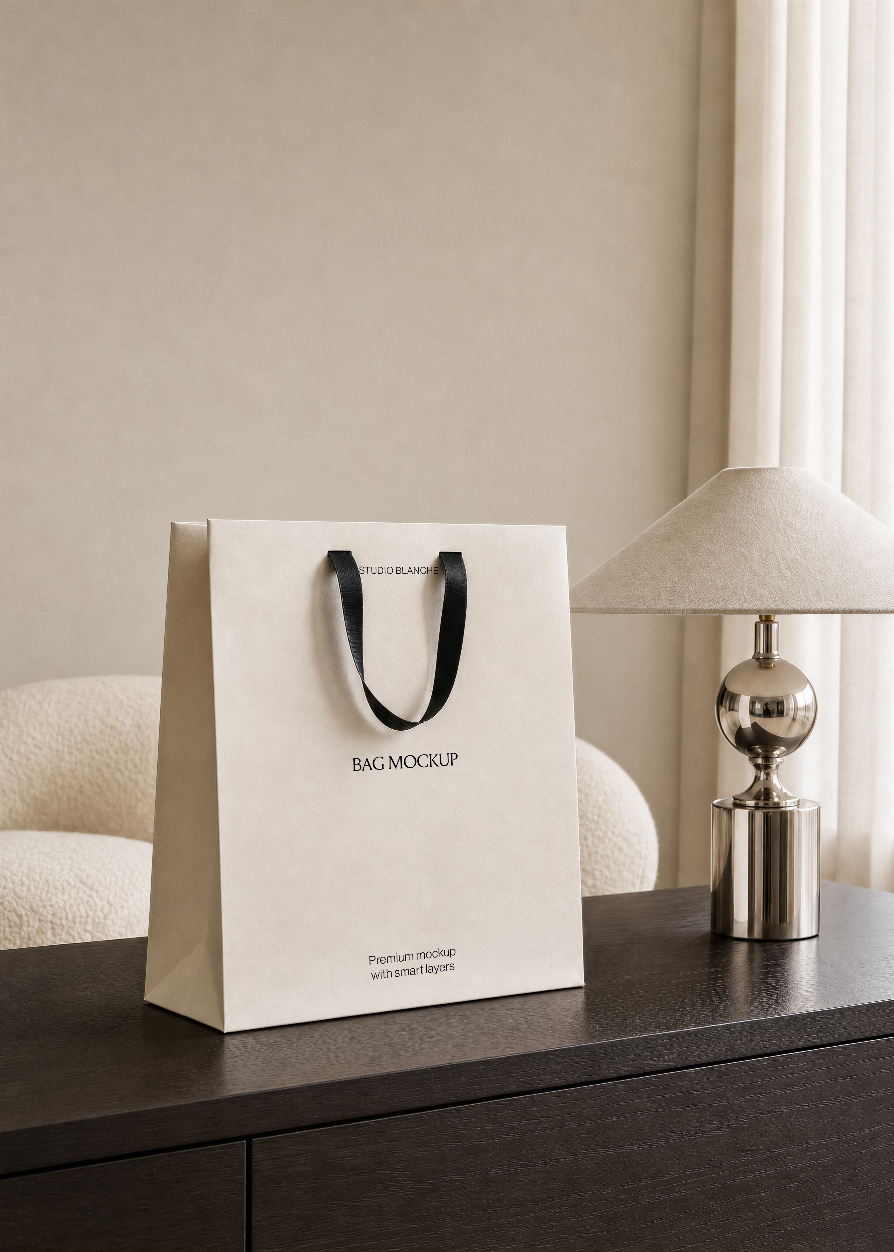 Cream paper carrier bag mockup showing logo area below ribbon handles, boucle chair and sheer curtain behind