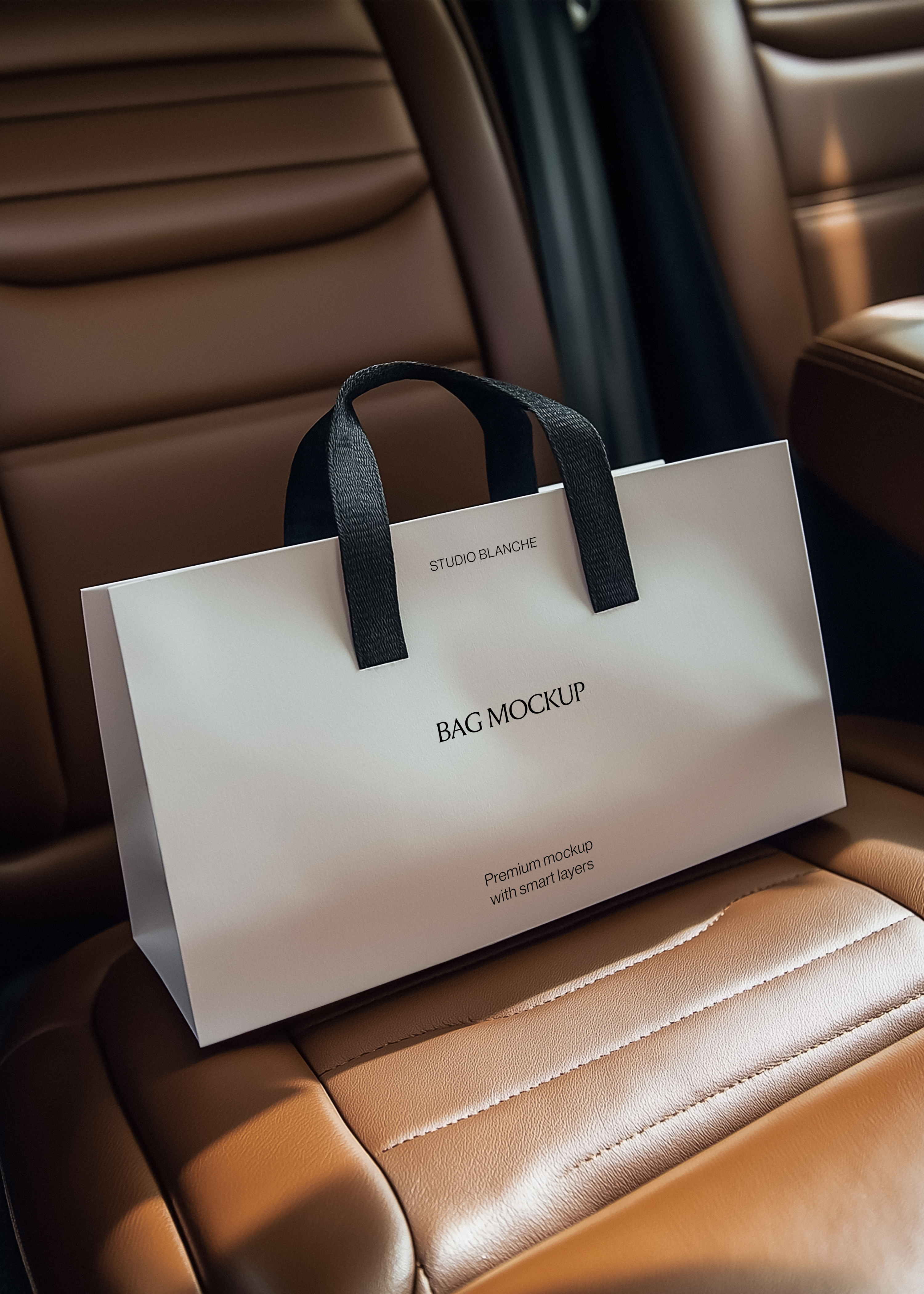 White paper shopping bag mockup with black handles on a cognac quilted car seat, seatbelt visible in warm sun