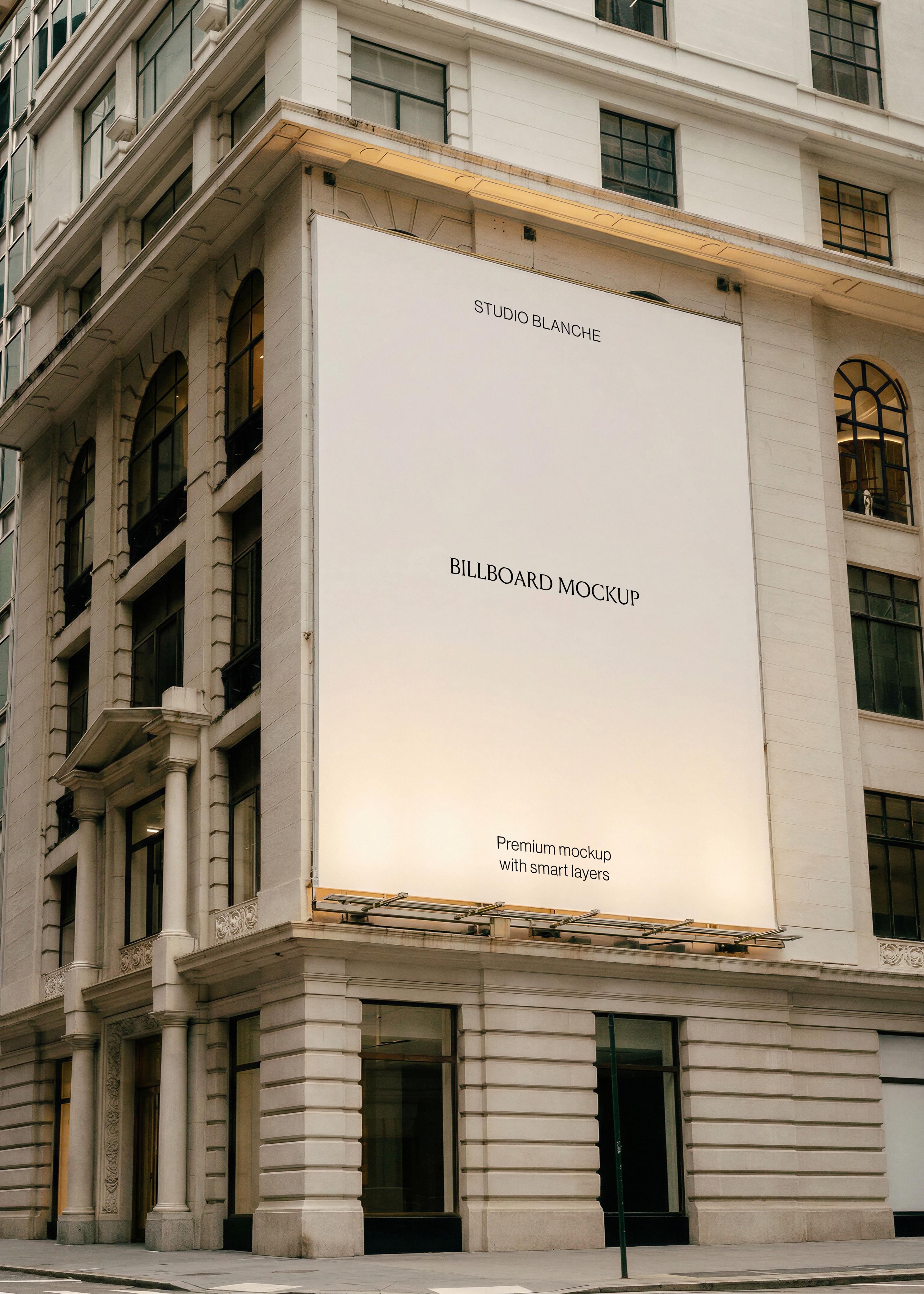 Large blank billboard mockup wrapping the corner of a classic stone city building above street-level shopfronts