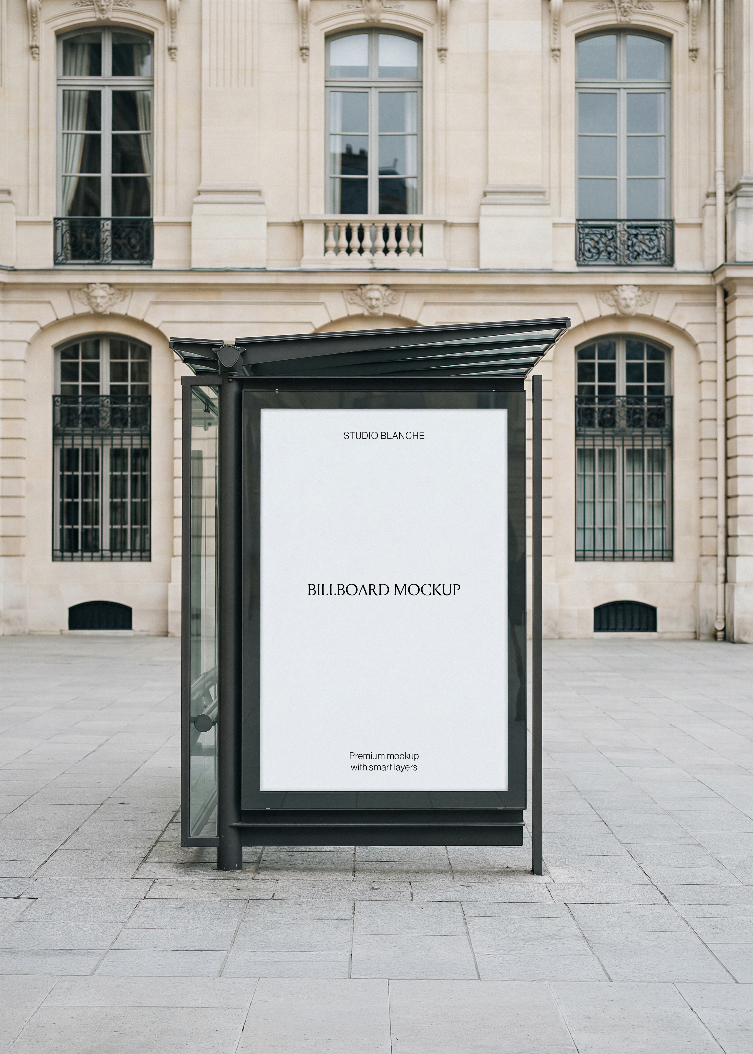 Blank billboard mockup in a dark glass bus shelter on a paved square before a Haussmann stone building