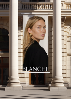 Hanging billboard mockup between Corinthian columns in warm sunlight, white banner displaying fashion campaign artwork