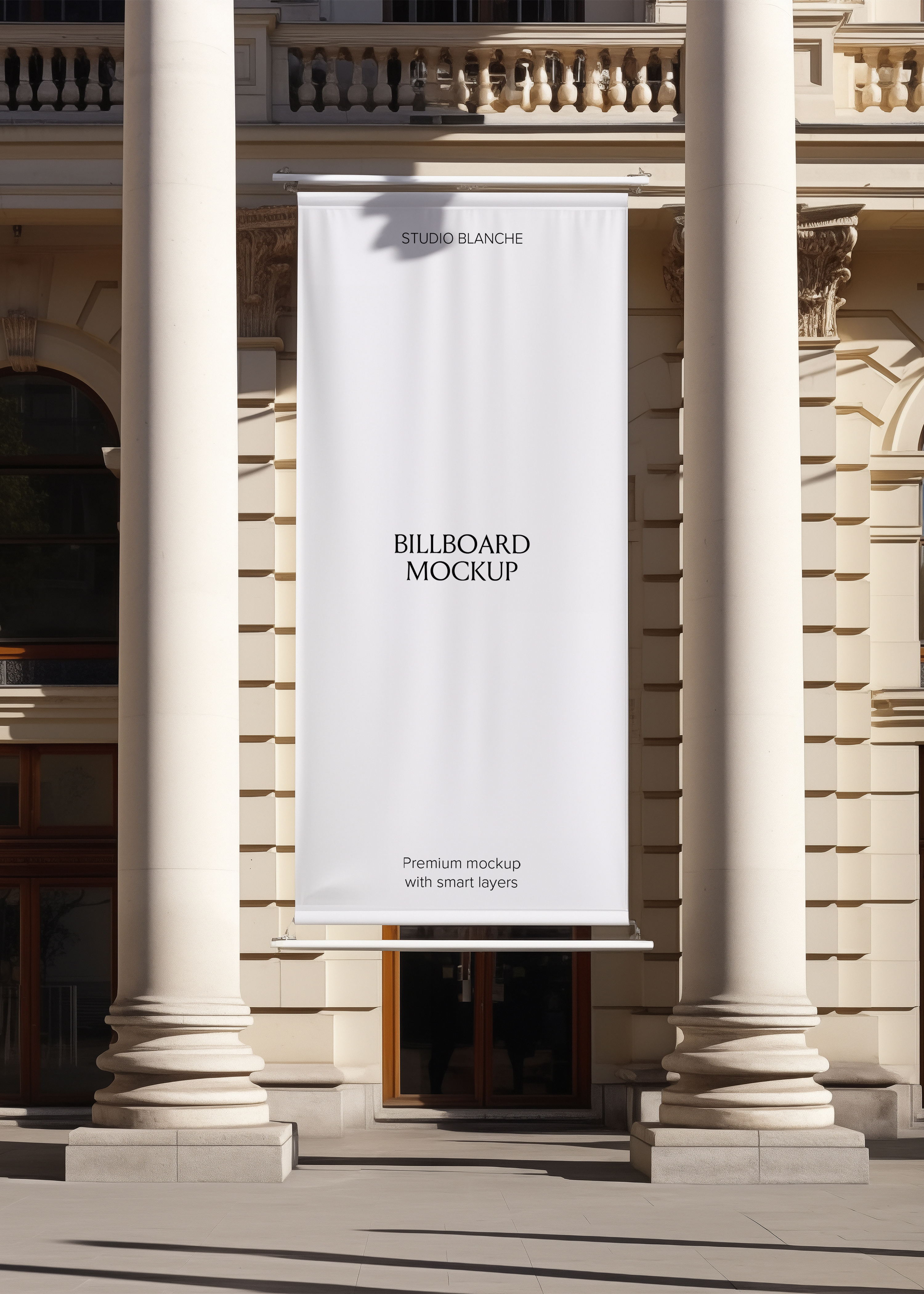 Blank hanging billboard mockup at a sunlit neoclassical entrance, empty white banner with Studio Blanche label