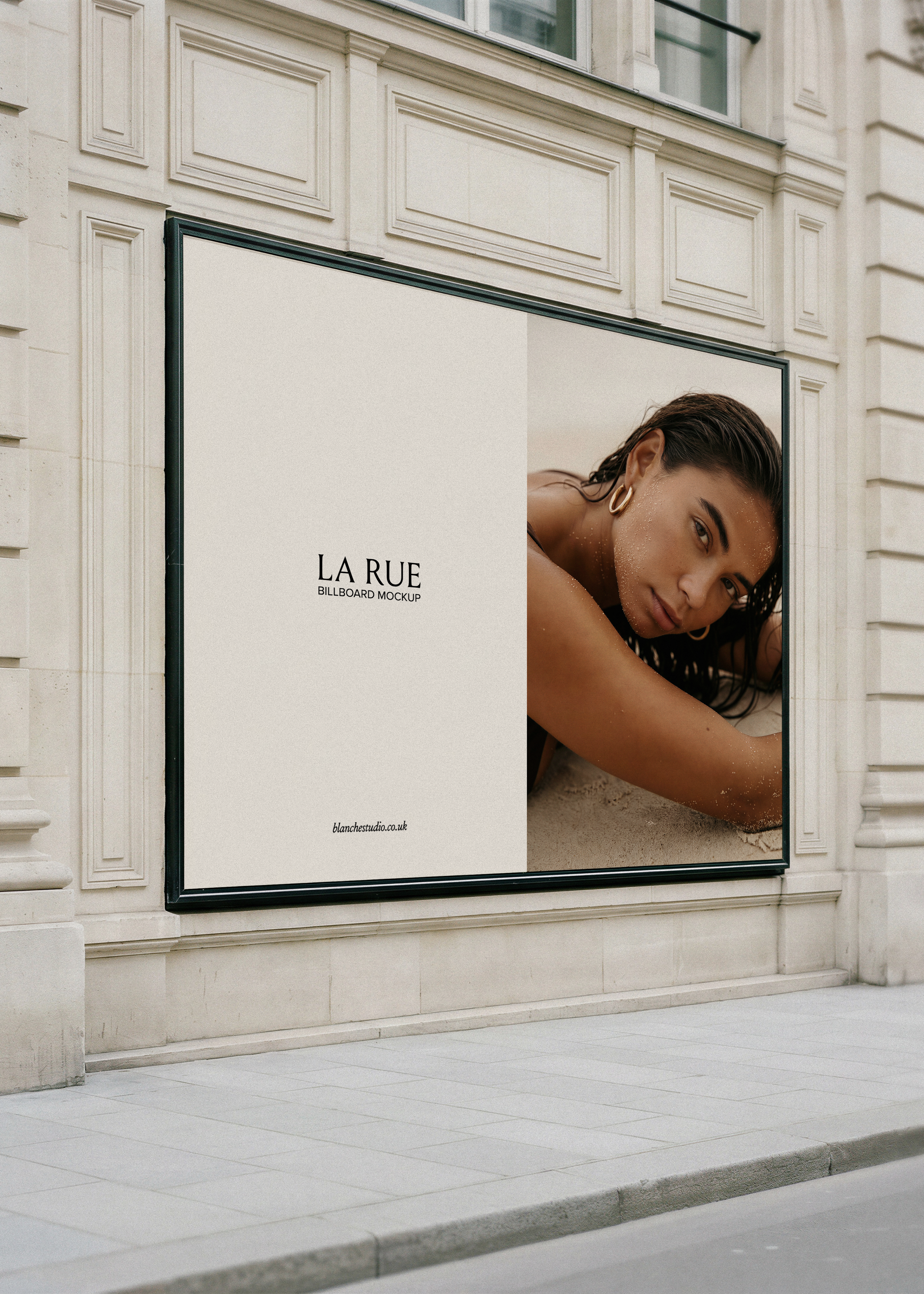 Billboard mockup displaying a luxury fashion campaign with editorial portrait photograph on a Parisian limestone building facade, from Studio Blanche