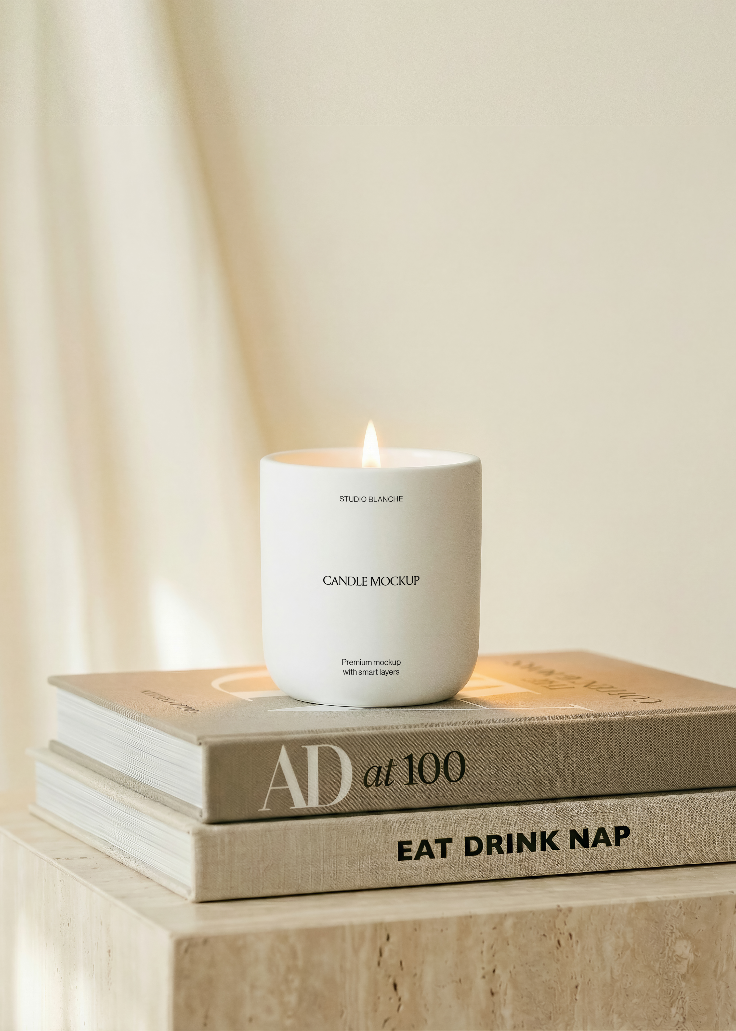 Candle mockup close-up of a matte white vessel with a lit wick and warm glow on a taupe linen book cover, soft cream light