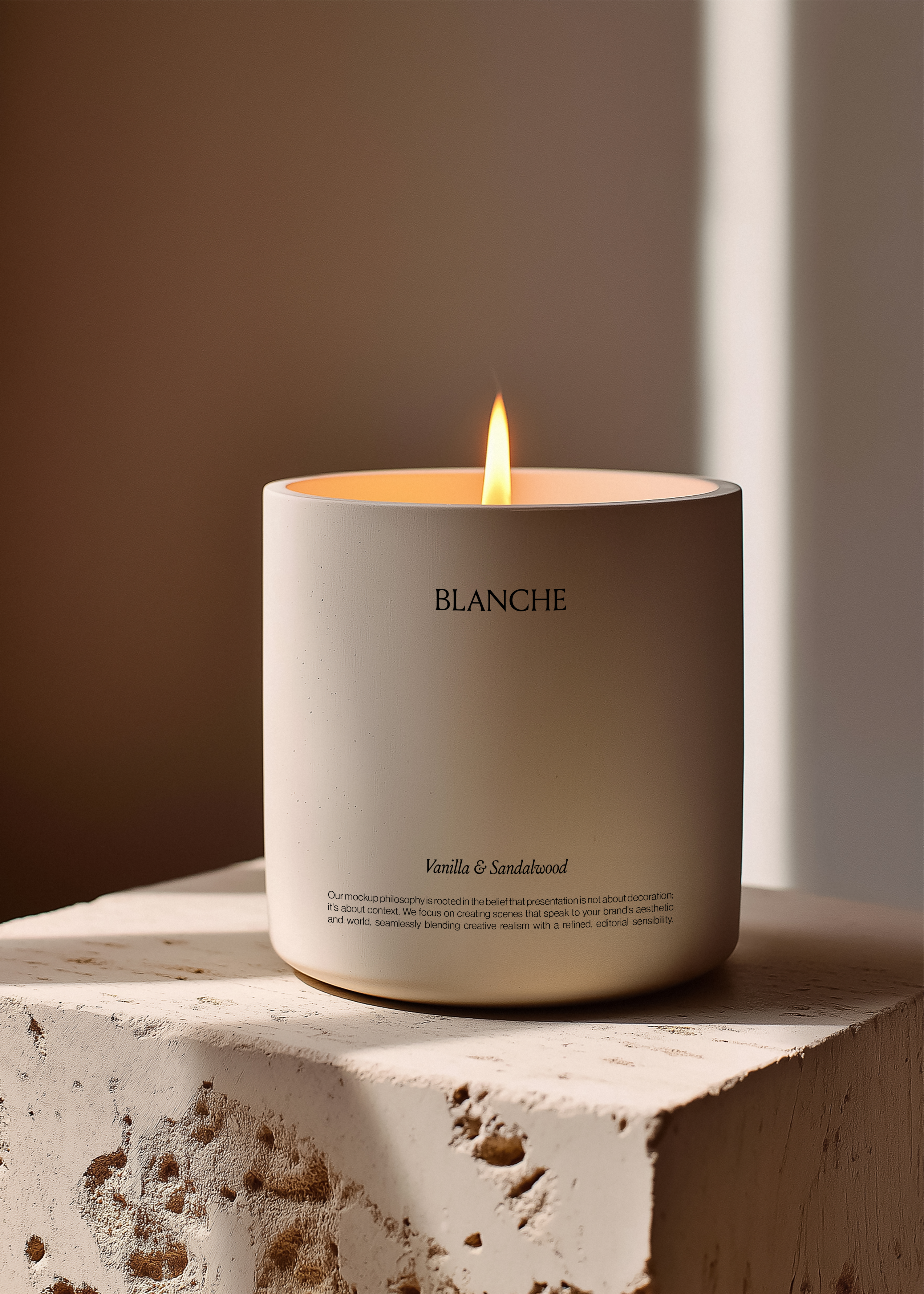 Pale concrete candle vessel with tall flame on rough stone plinth, deep terracotta wall with raking light behind