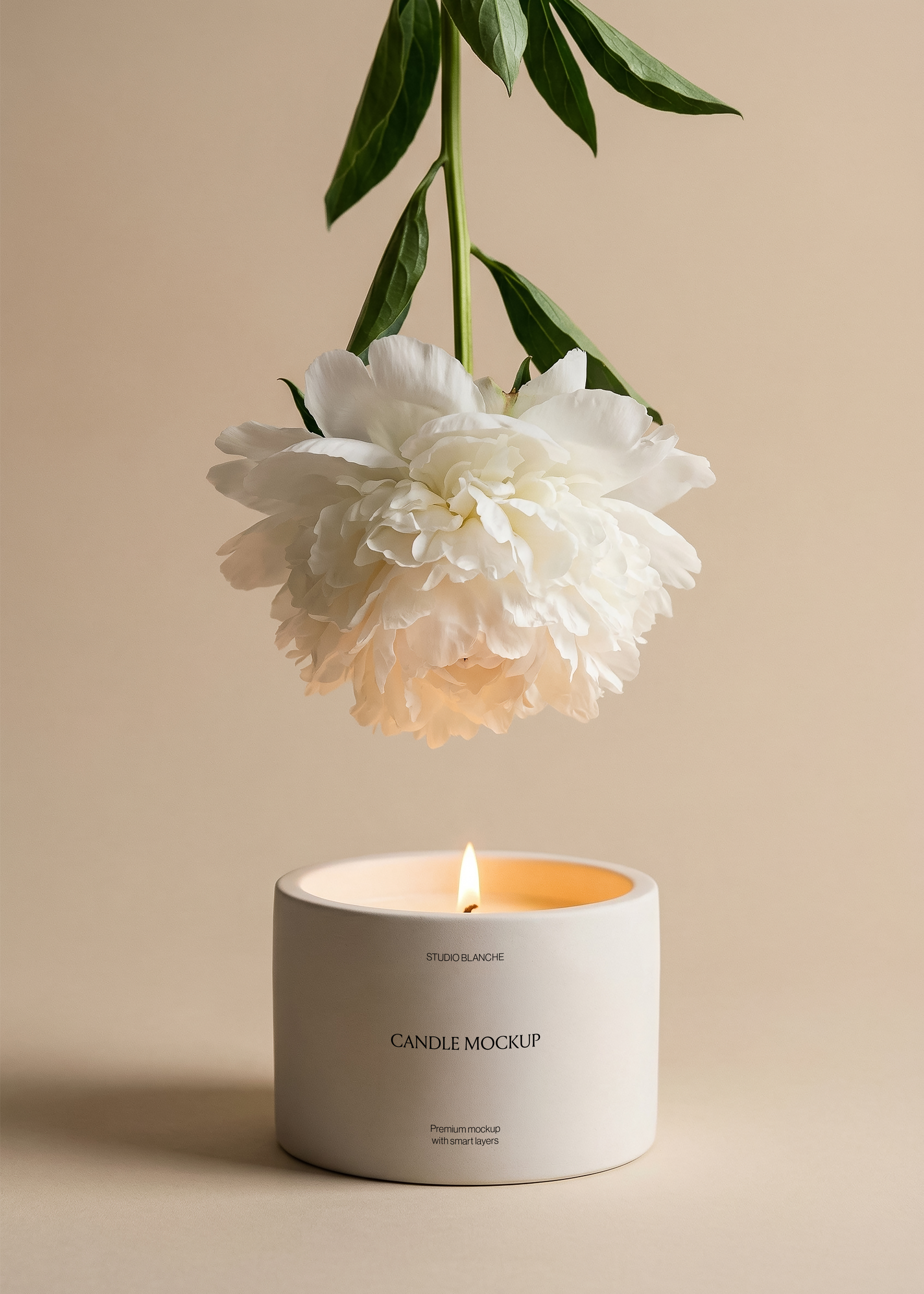Low-profile ceramic candle vessel mockup showing label area, white peony suspended above, tropical leaf prop, warm beige background