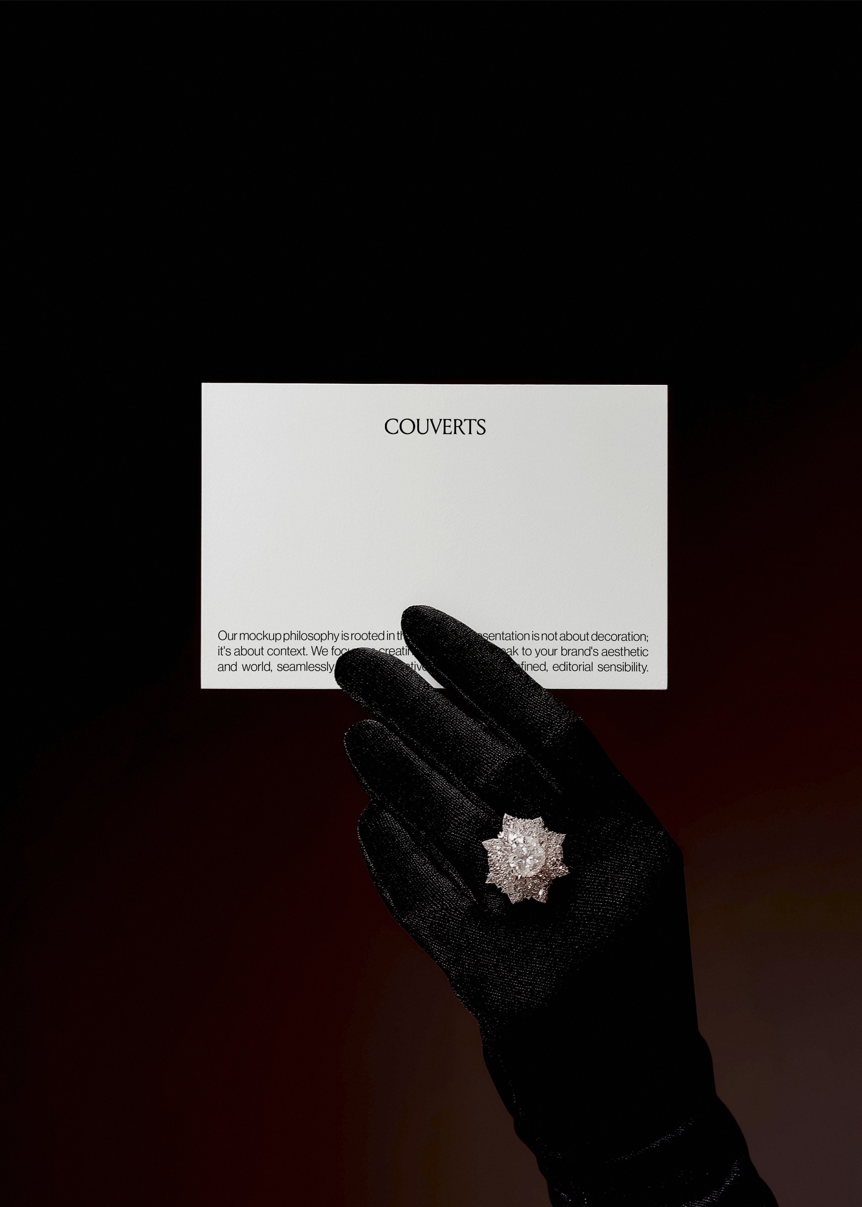 Landscape card mockup floating against dark red and black gradient, gloved hand with starburst diamond ring reaching toward it