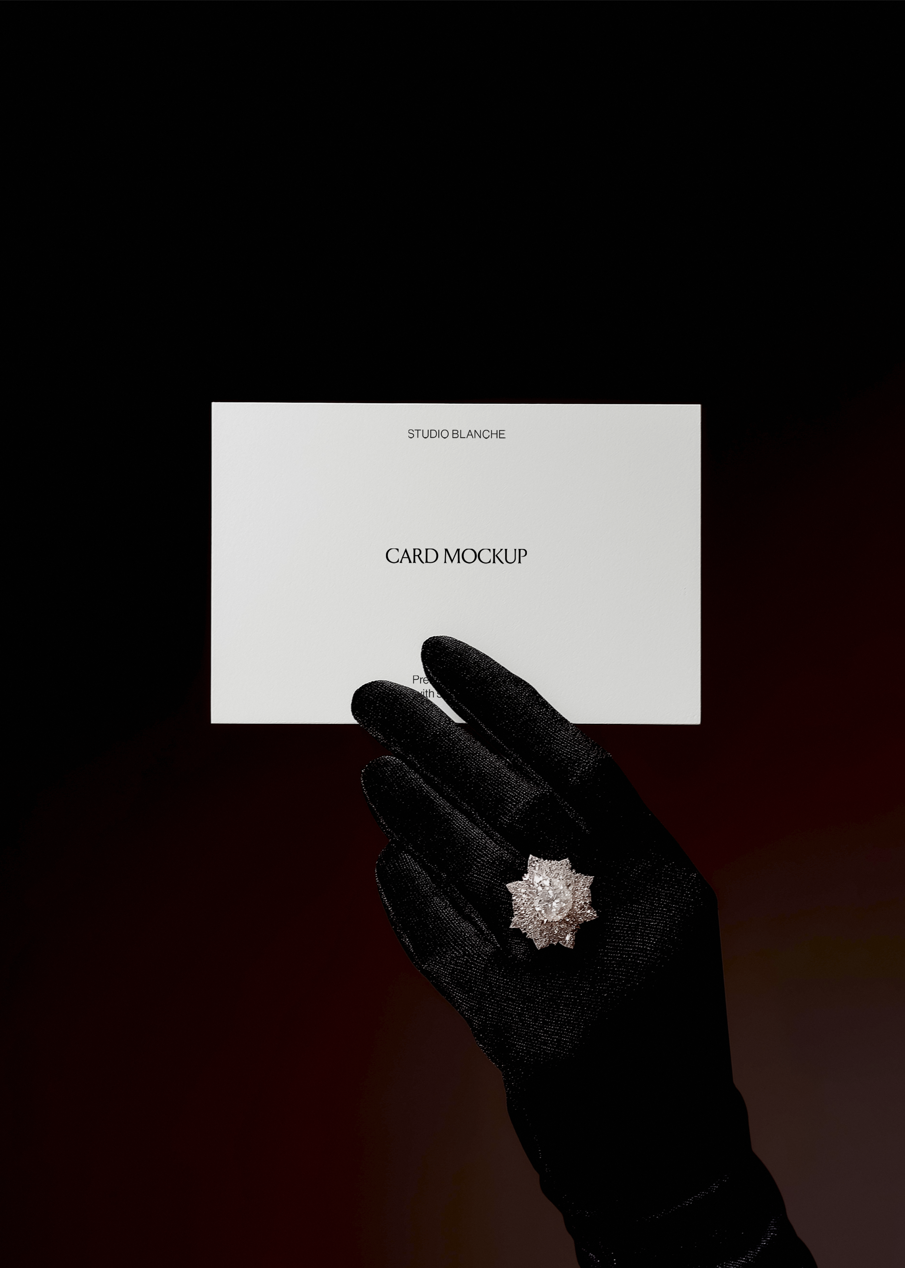 Card mockup detail showing sheer black lace glove and diamond ring beneath white card with black text