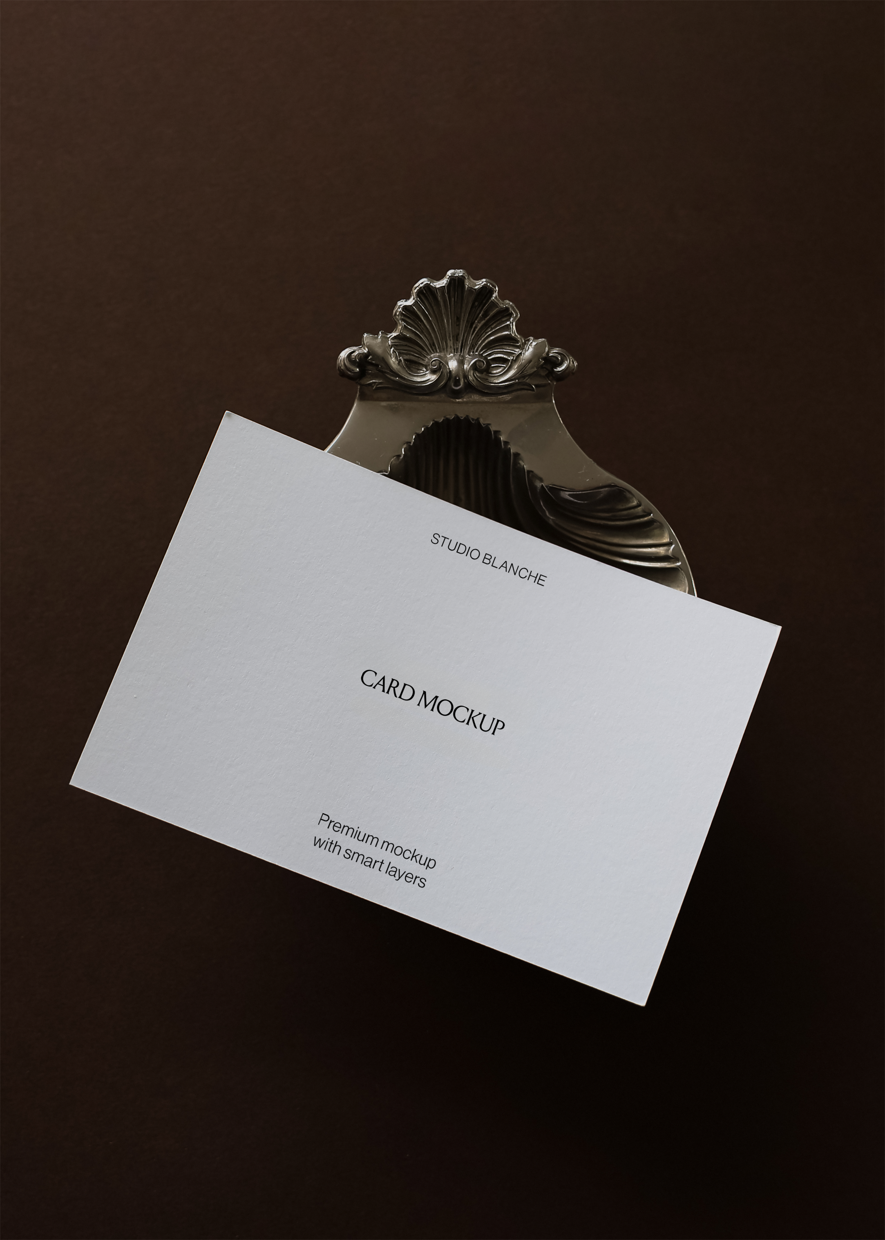 Card mockup detail showing angled placement in engraved shell and scroll clip, white card with black text