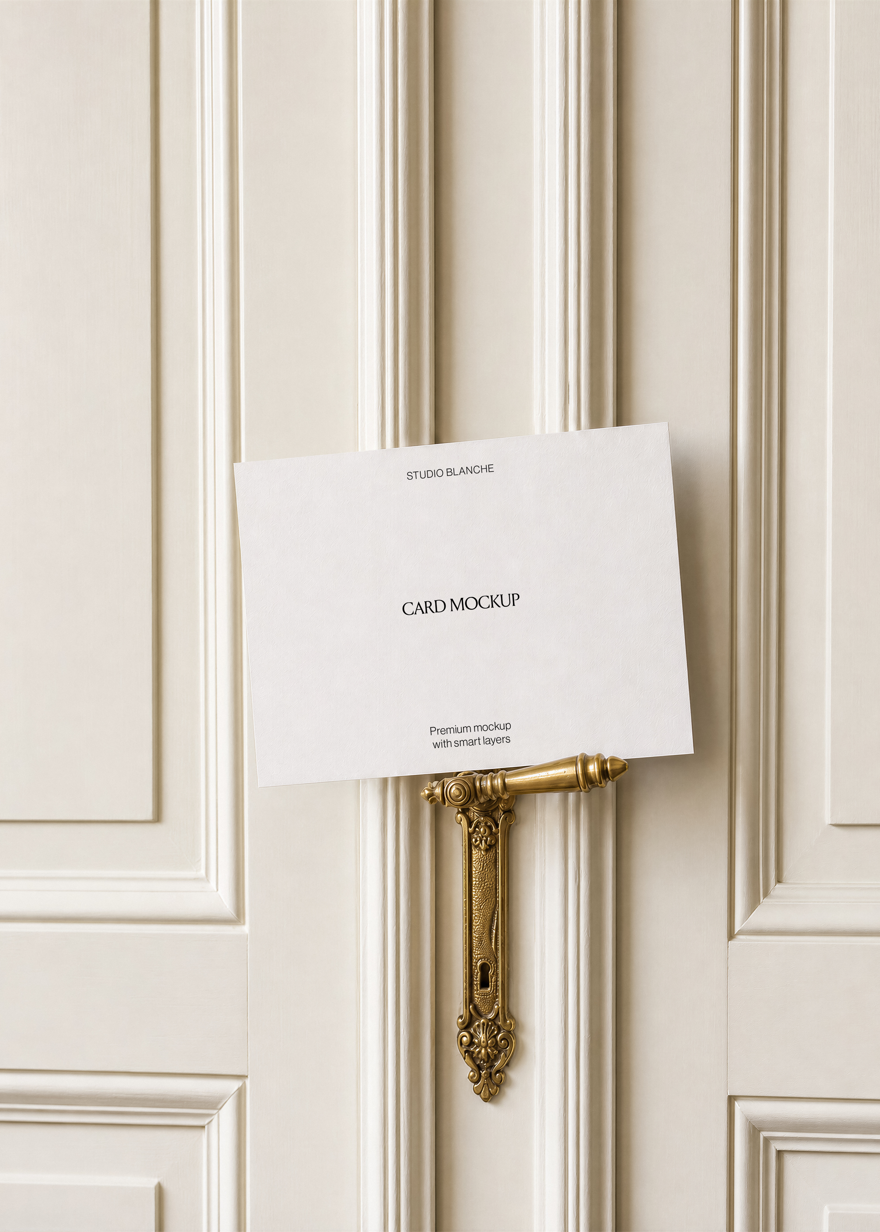 Blank card mockup balanced on a brass lever handle with keyhole plate, cream panelled door background