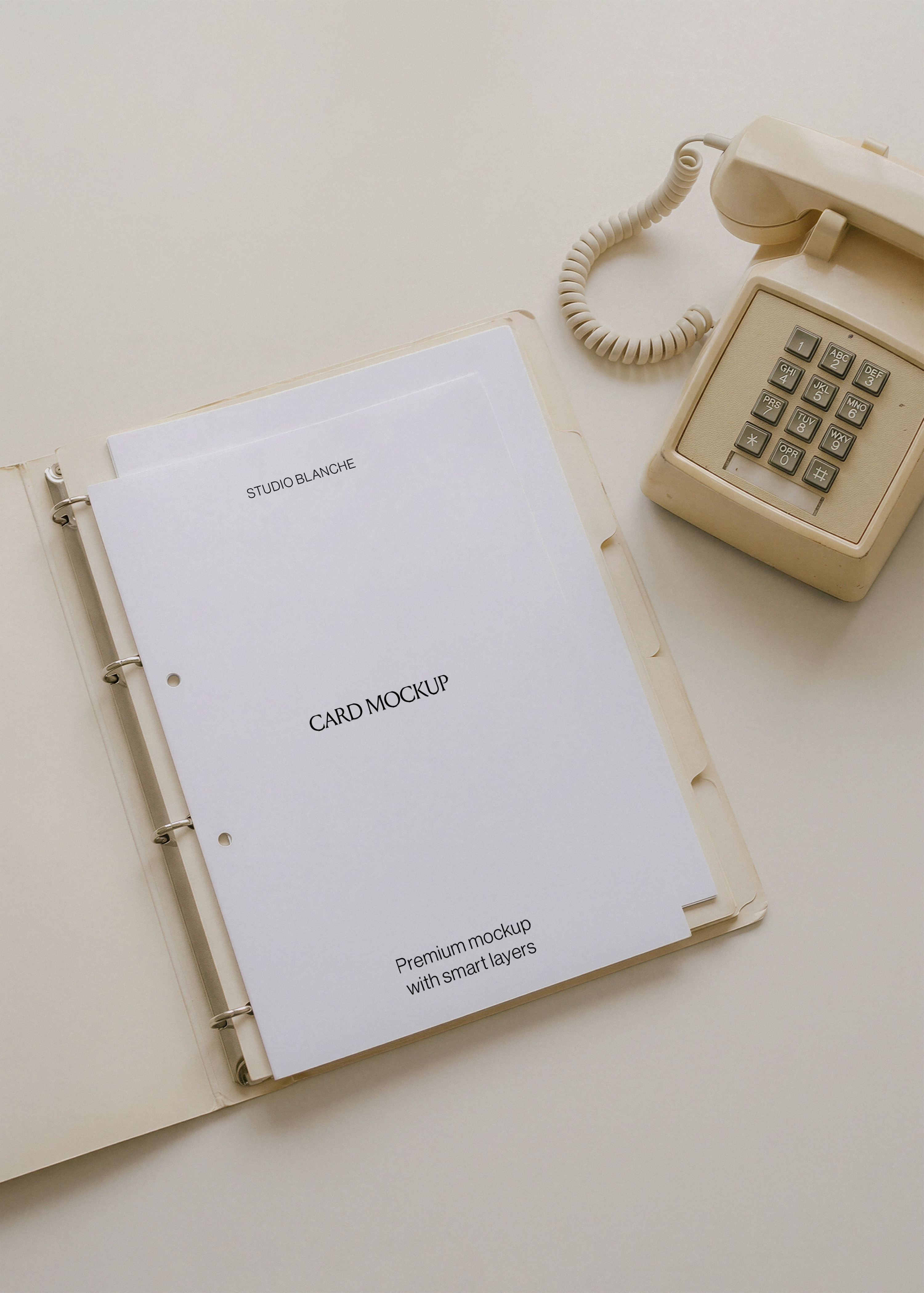 Blank A4 letterhead in open ring binder with cream dividers, retro corded push-button phone on pale desk, flat lay view