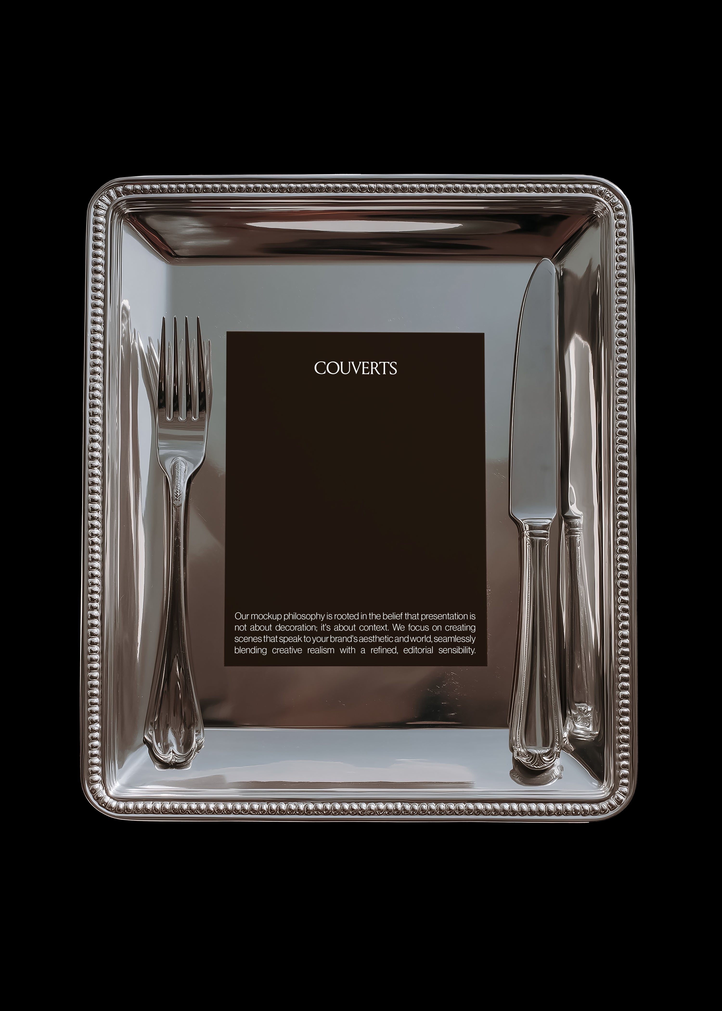 Portrait card mockup centred on beaded-edge silver tray with fork and knife framing it symmetrically, black background