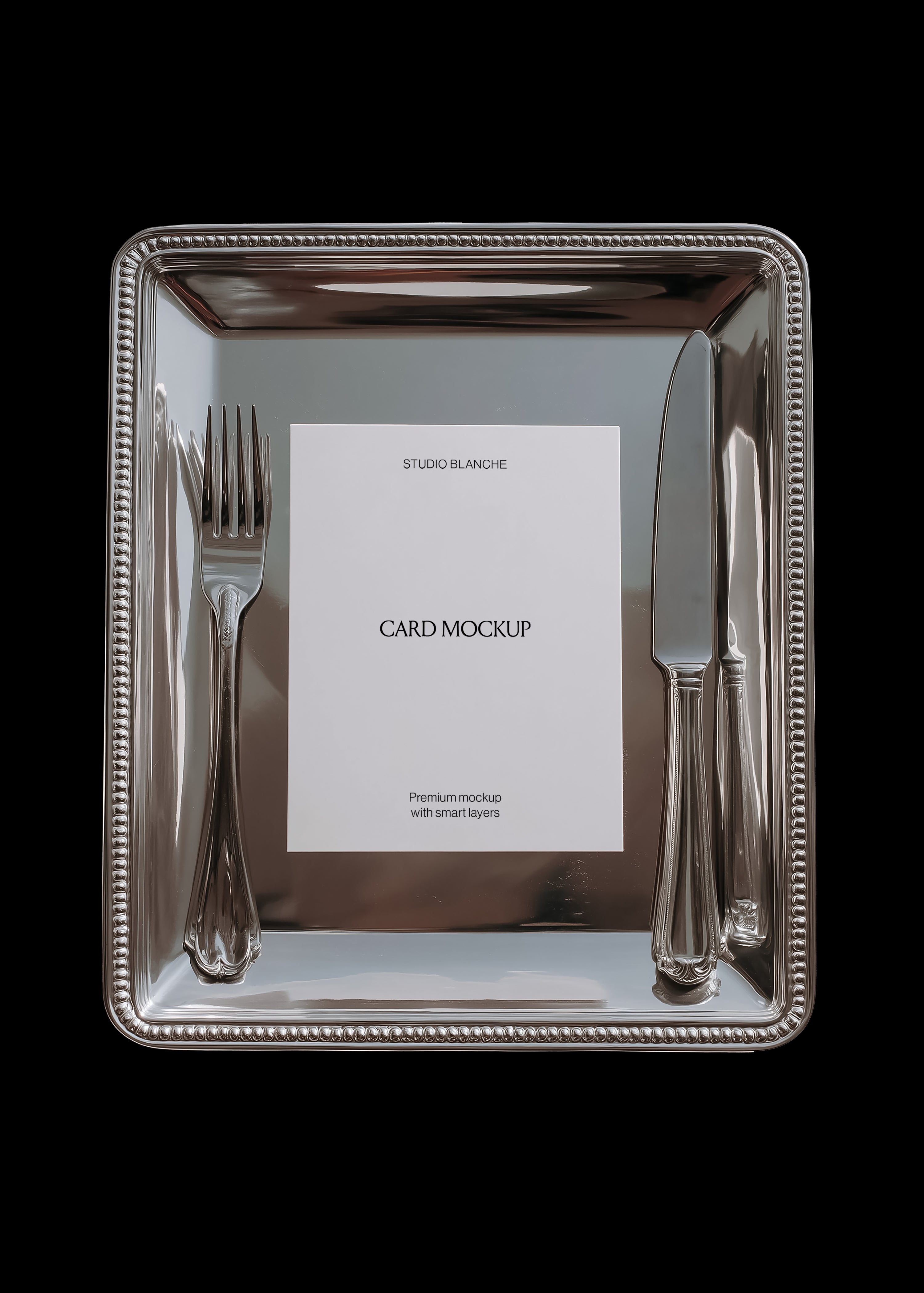 Card mockup detail on rectangular silver tray showing beaded rim, matched cutlery, and white card with black text