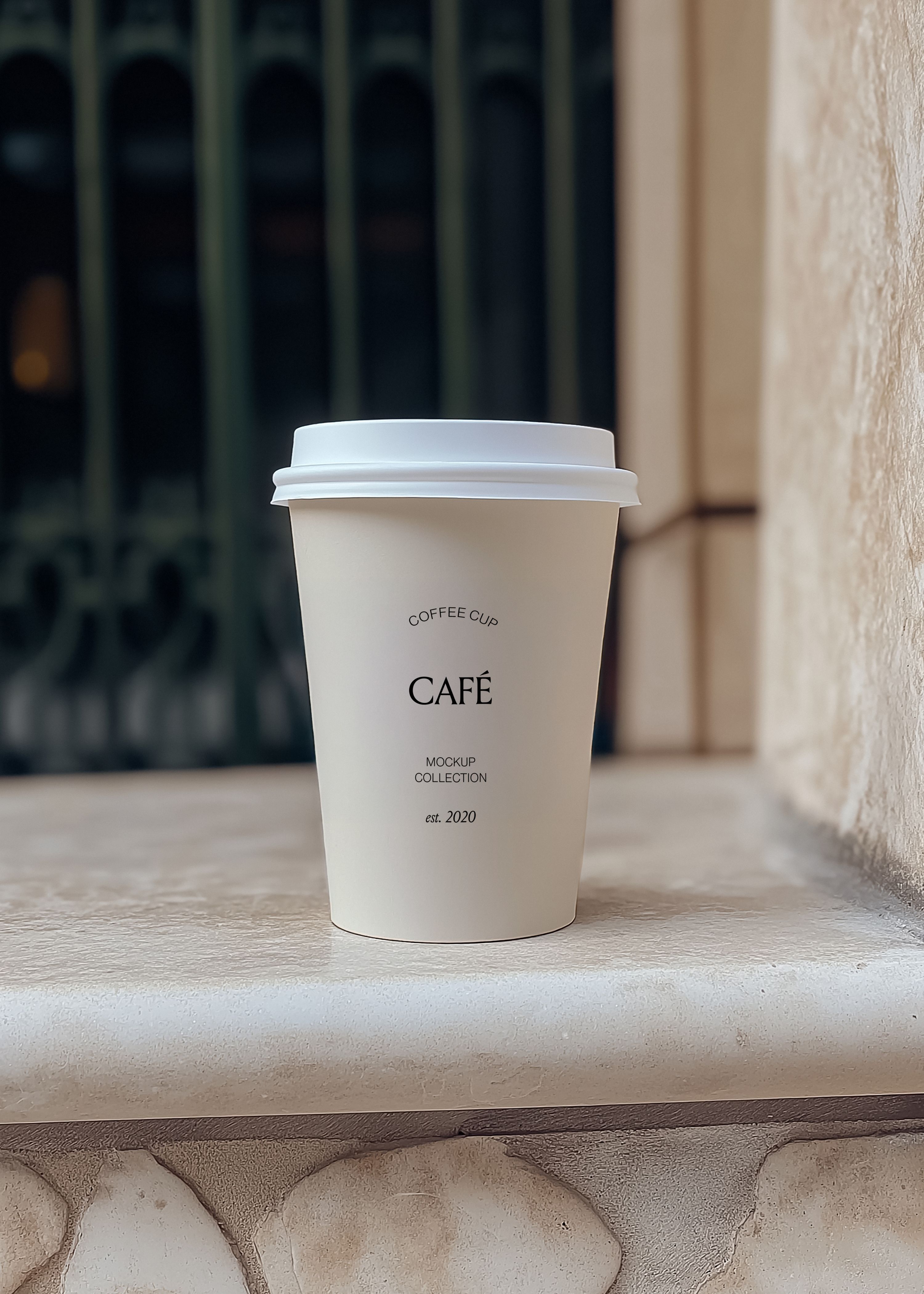 White takeaway coffee cup mockup on a pale stone window ledge with a dark green shuttered window behind