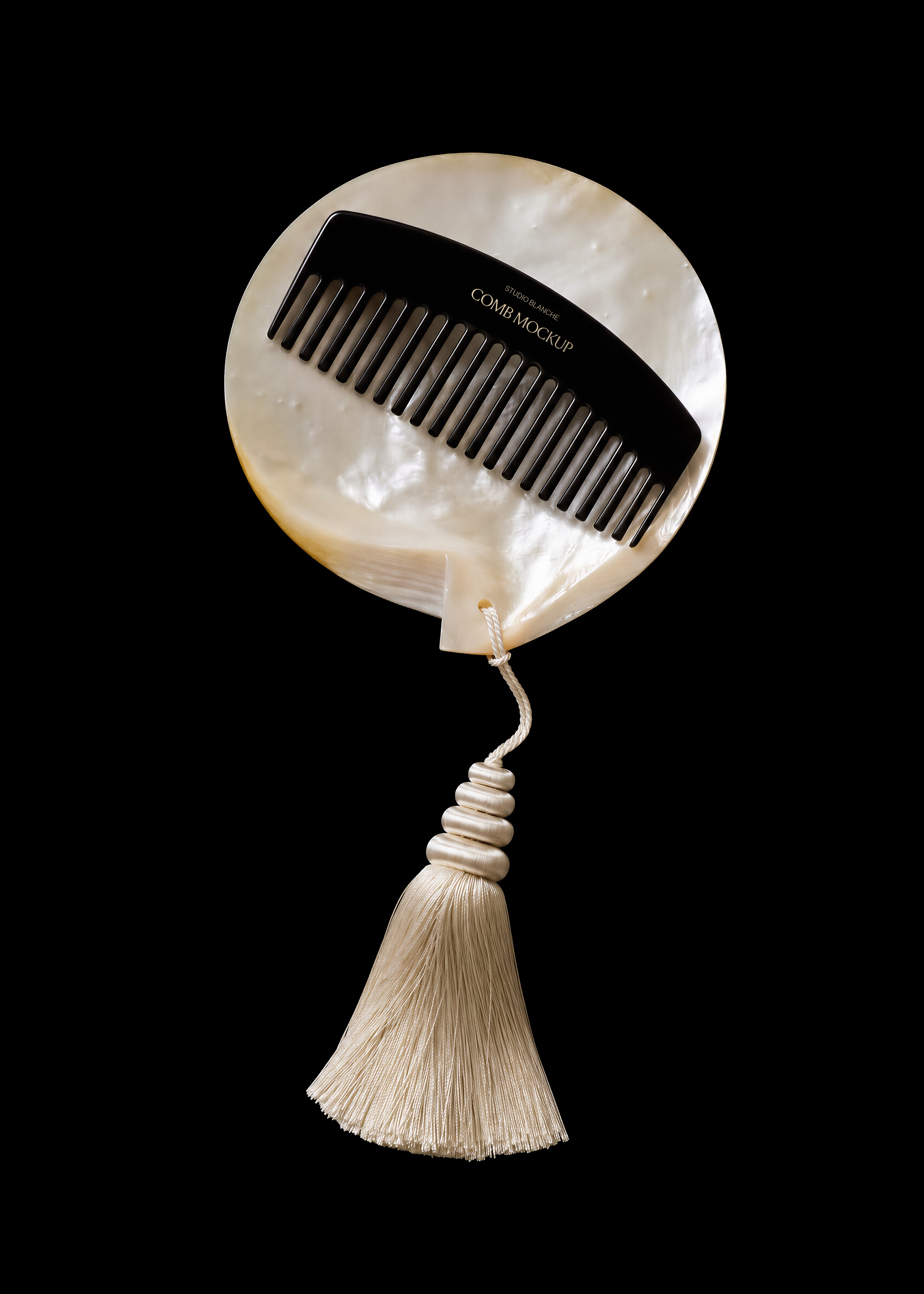 Comb mockup on iridescent pearl shell, gold foil branding on the spine, cream tassel below, dark editorial styling
