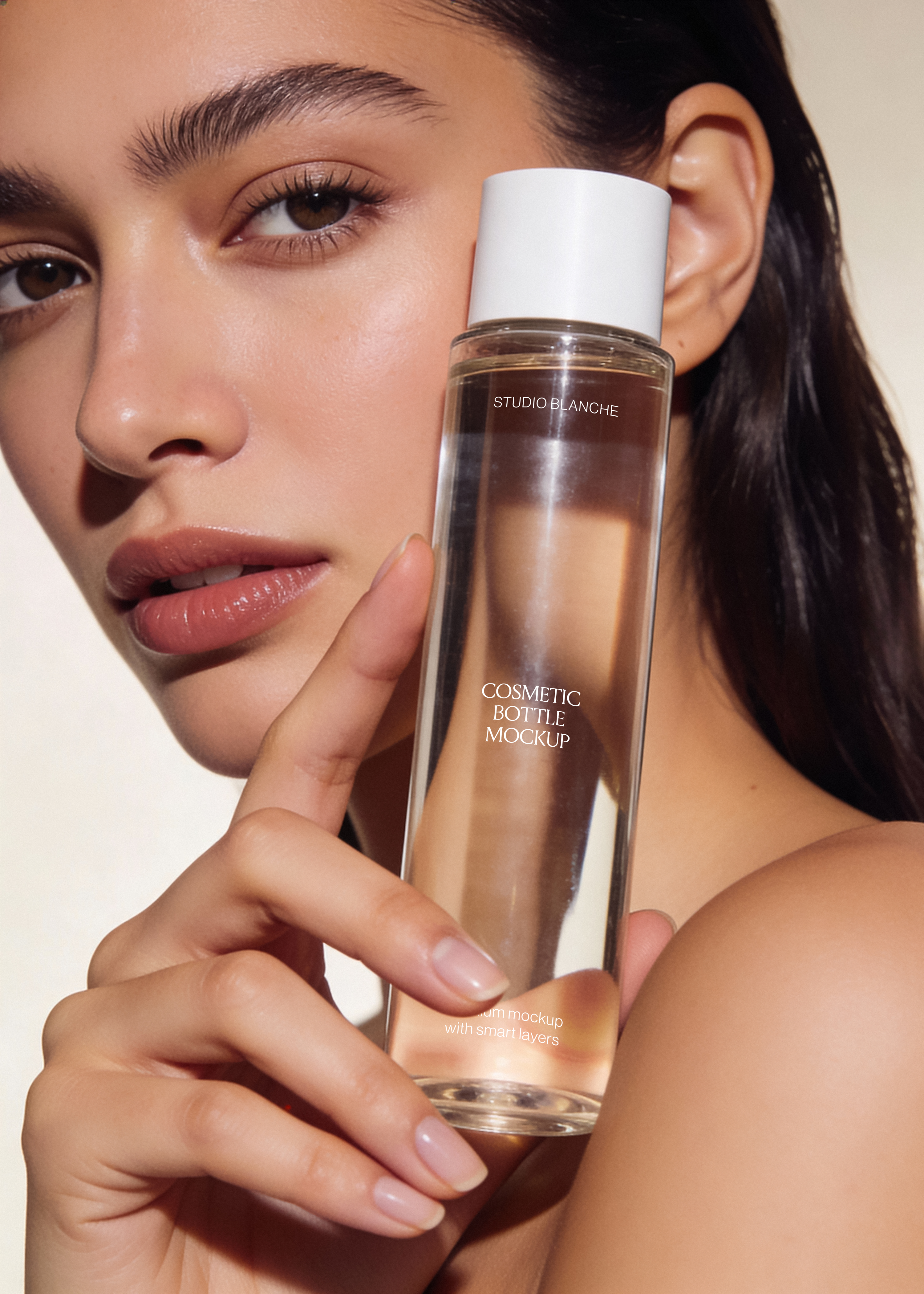 Cosmetic bottle mockup with serif label and white cap resting by a model's face, warm skin tones, editorial lighting