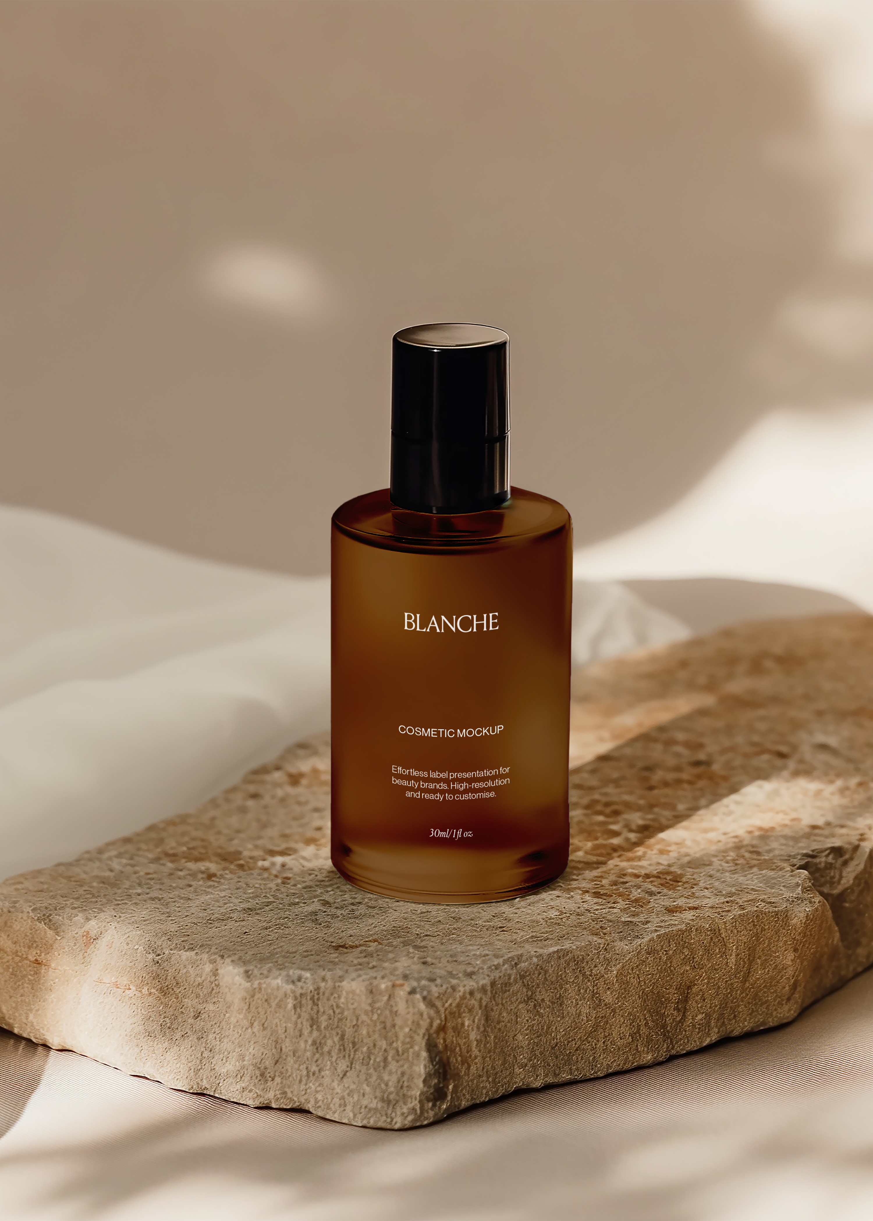 Amber frosted glass cosmetic bottle mockup with black cap on a sandstone slab and cream fabric in warm sunlight