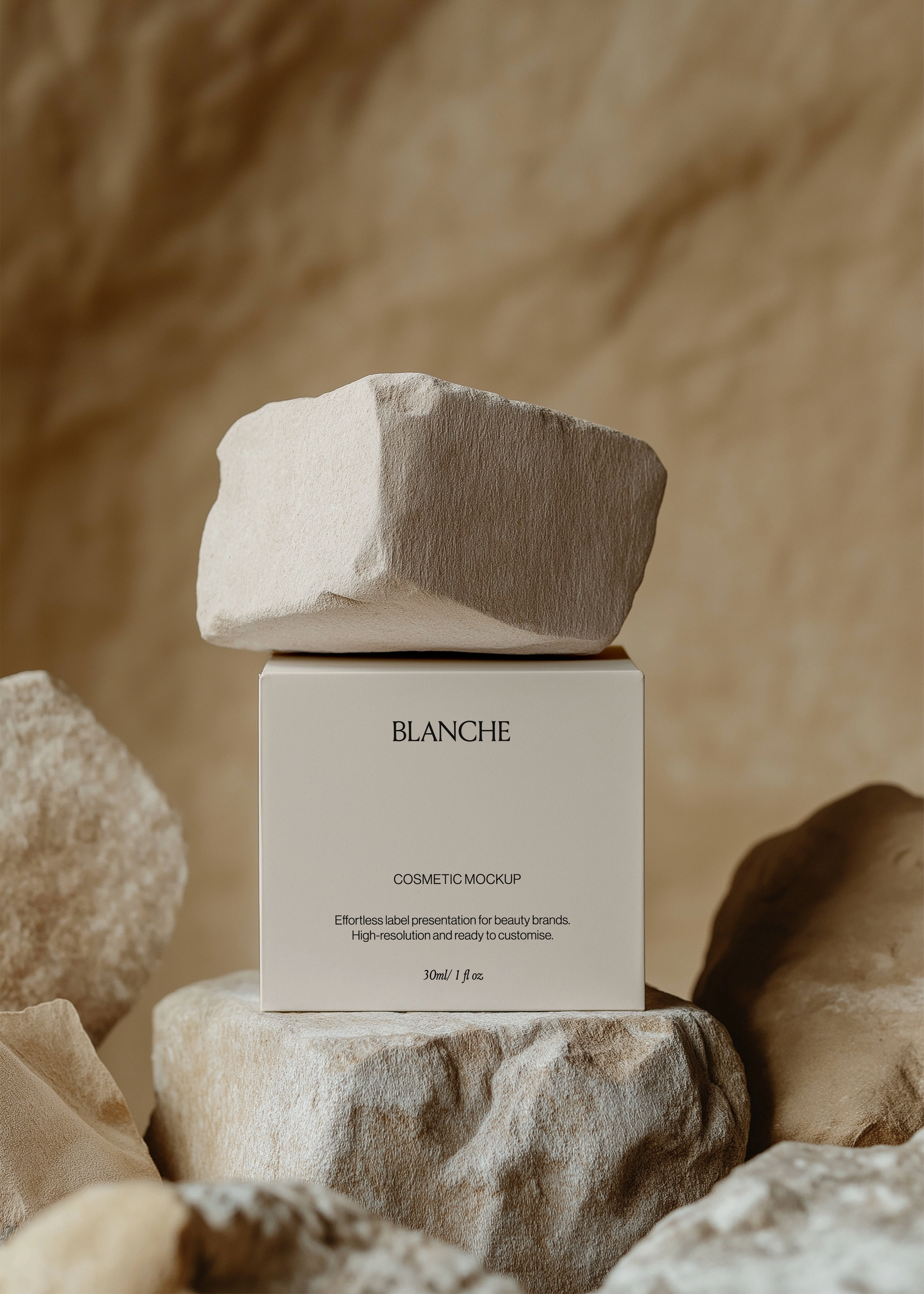 Square white cosmetic box mockup on a sandstone rock plinth with a raw stone resting on top against a warm beige backdrop