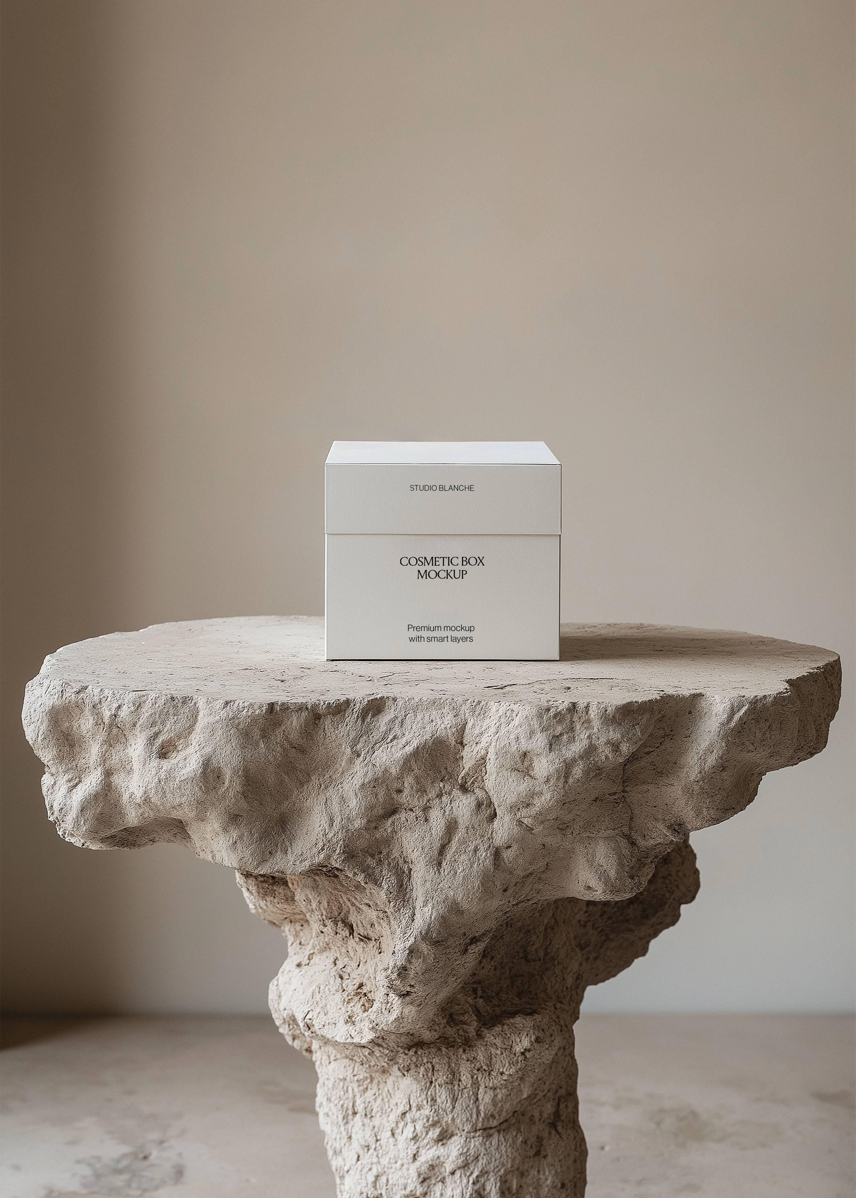 Front view of a white two-part cosmetic box mockup reading Studio Blanche on a textured stone pedestal in neutral tones