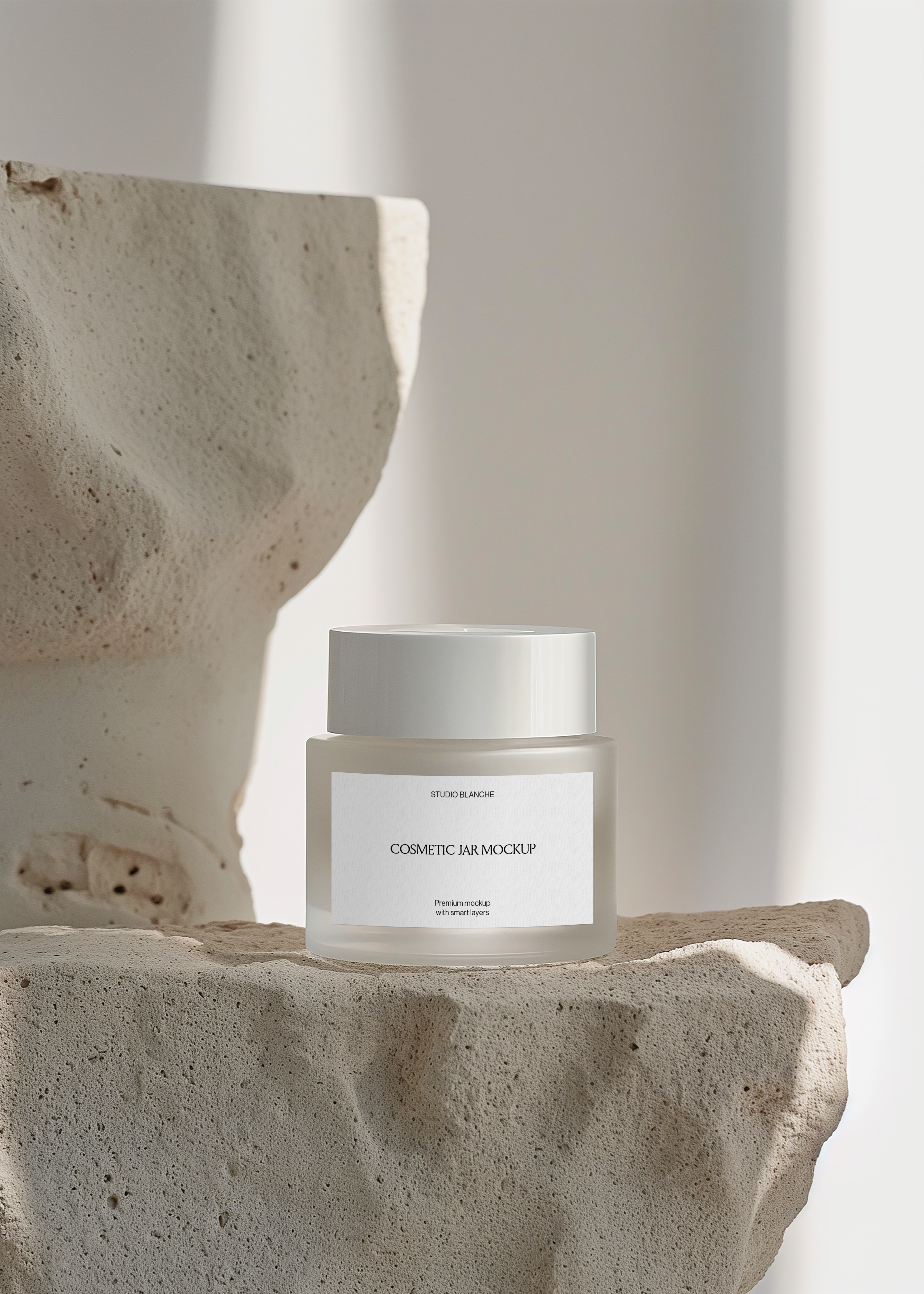 Frosted cosmetic jar mockup on textured stone shelf with sculptural limestone behind, bright minimal gallery scene