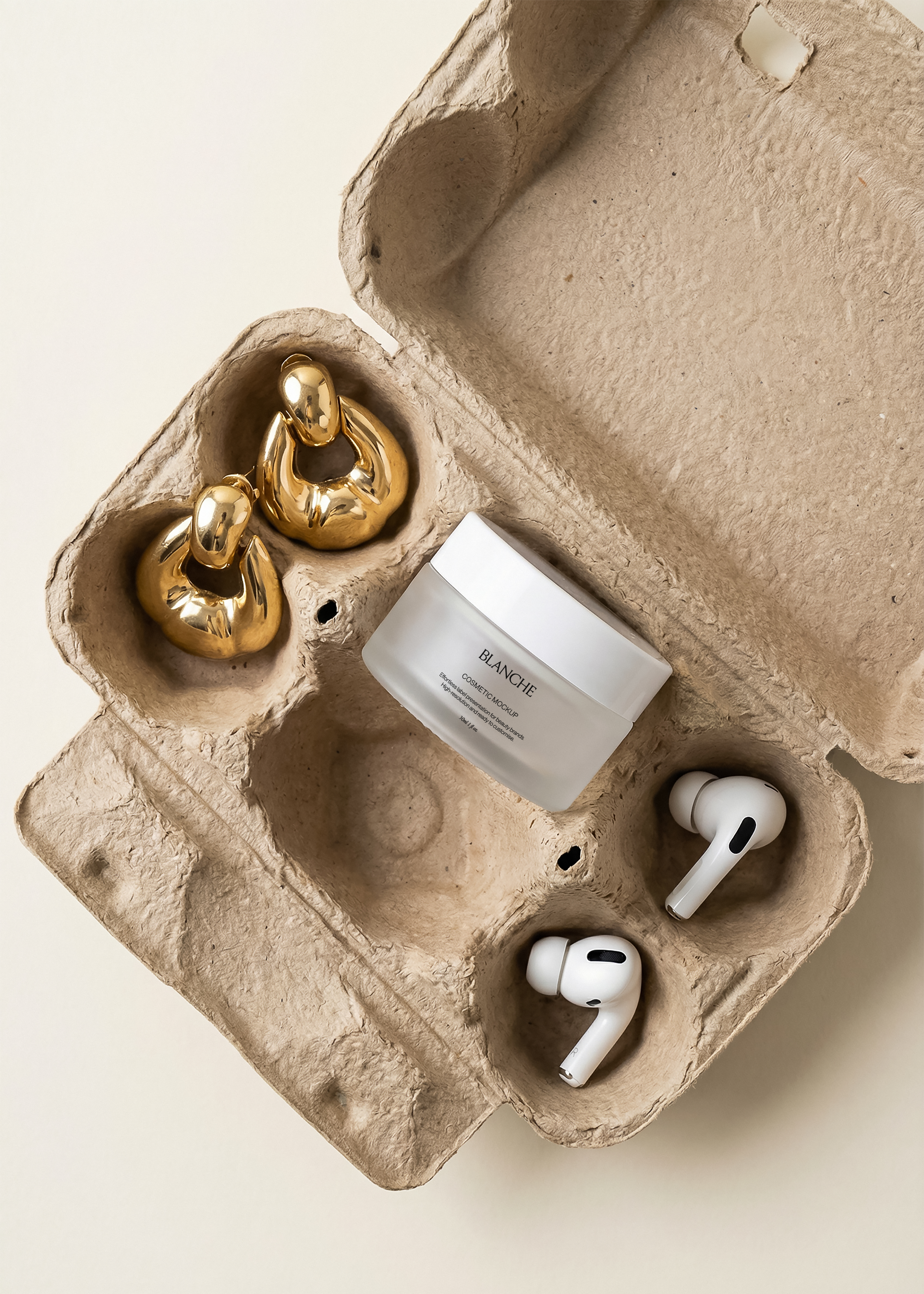 Frosted white cosmetic jar mockup in open cardboard egg carton with gold hoop earrings and white earbuds