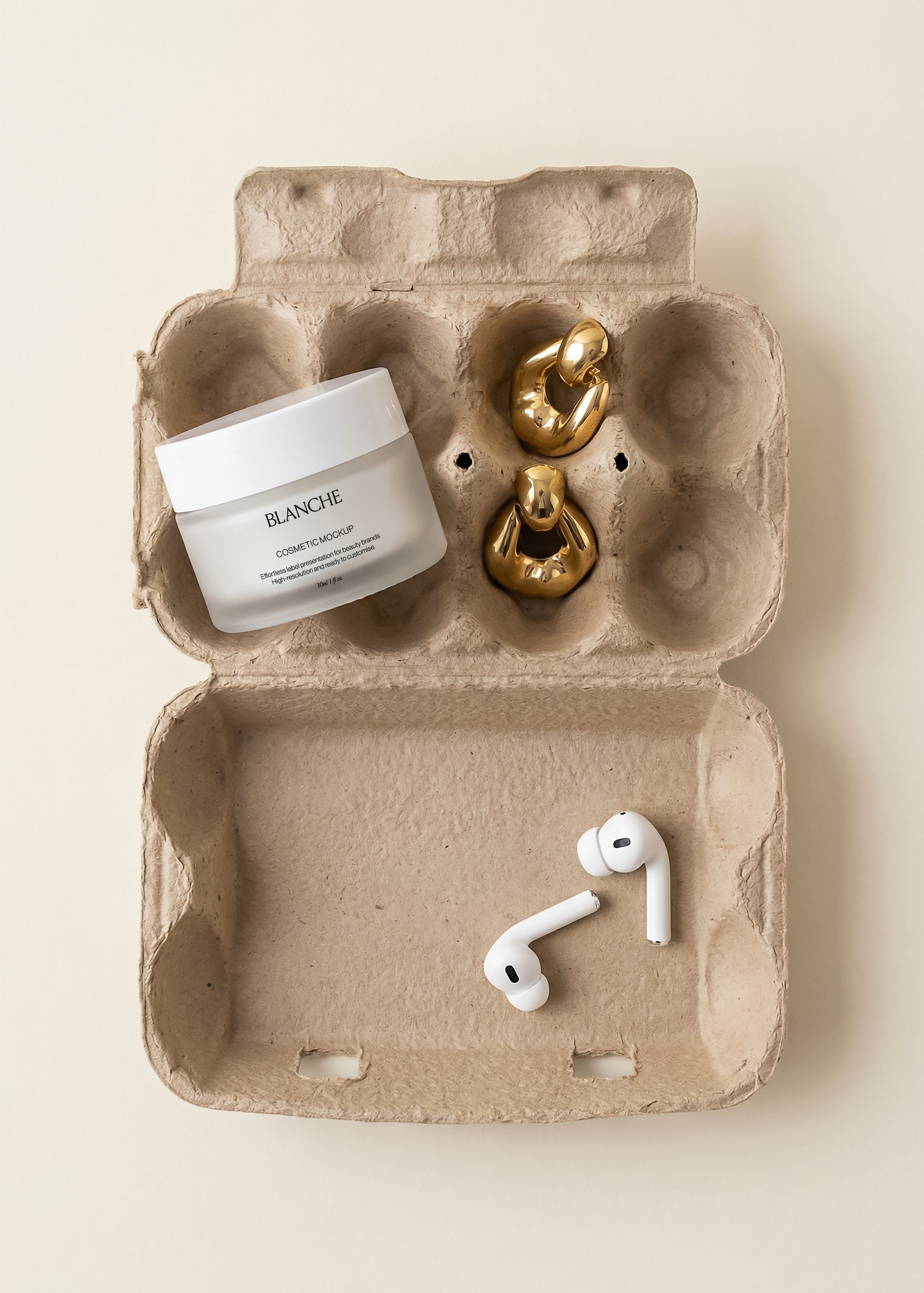 Frosted white cosmetic jar mockup in open cardboard egg carton with gold earrings and white wireless earbuds