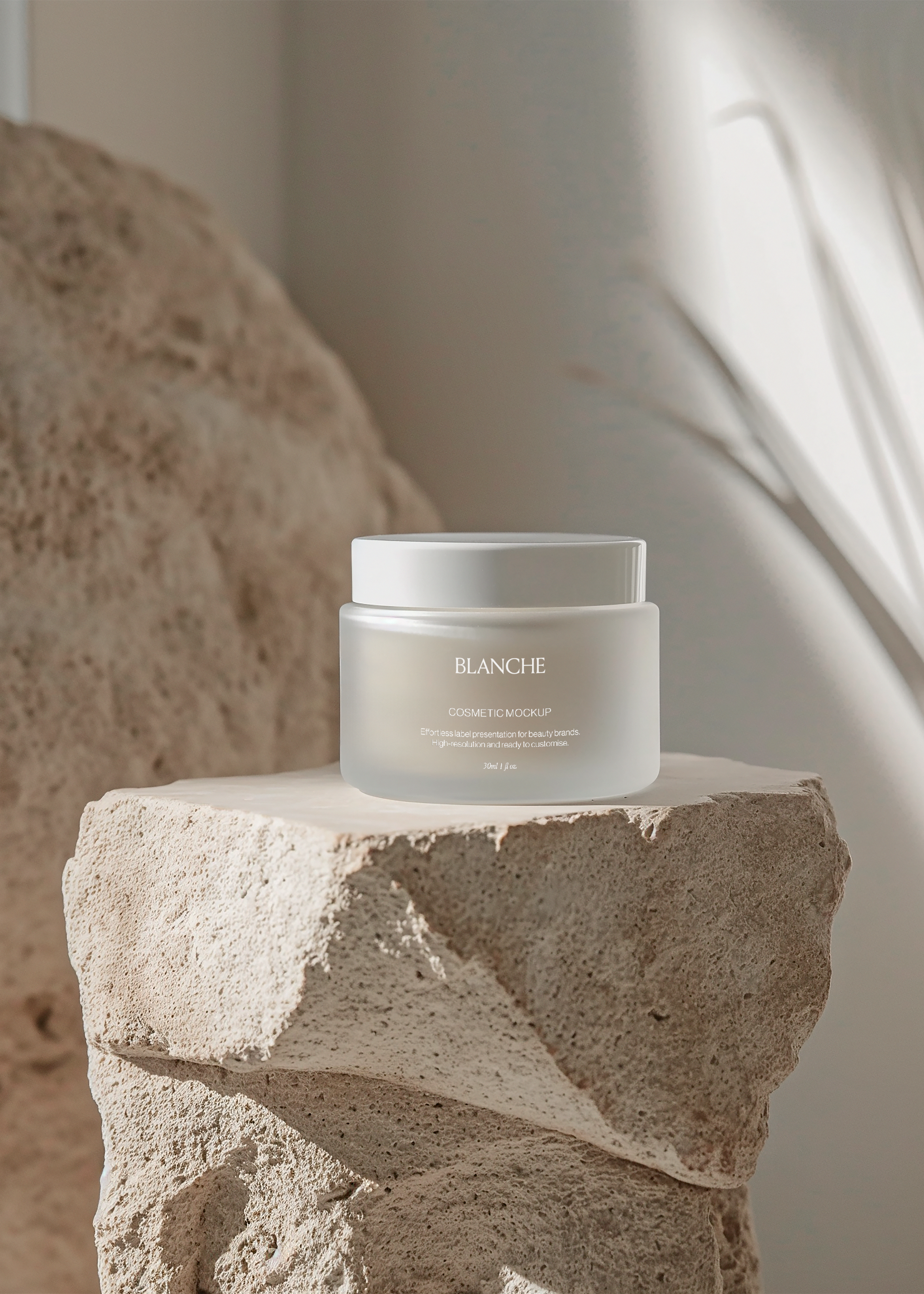 Frosted glass cosmetic jar mockup with matching lid on rough travertine plinth in soft daylight, sculptural scene