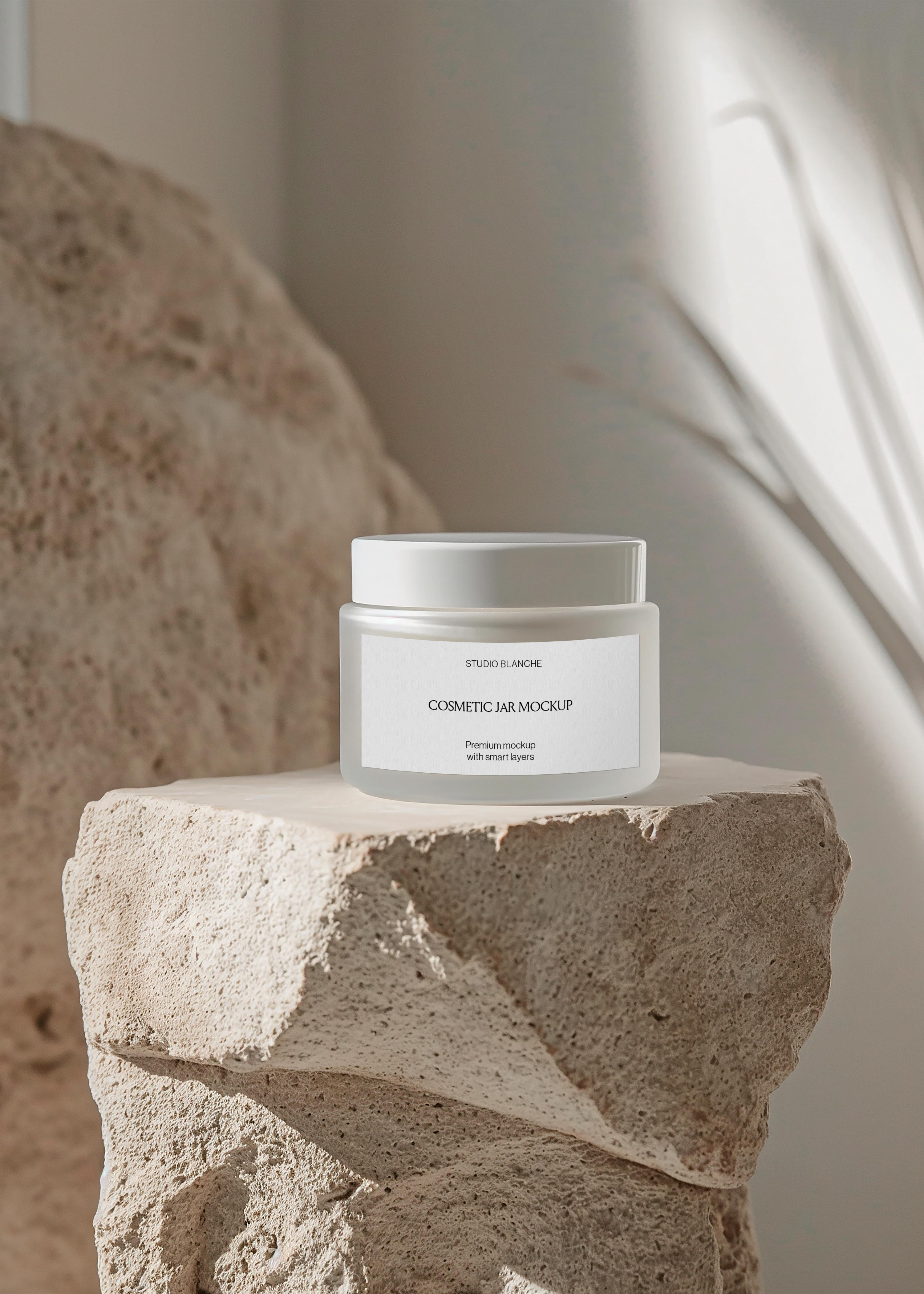 Frosted cosmetic cream jar mockup on textured stone block against warm plaster wall, minimal sculptural styling