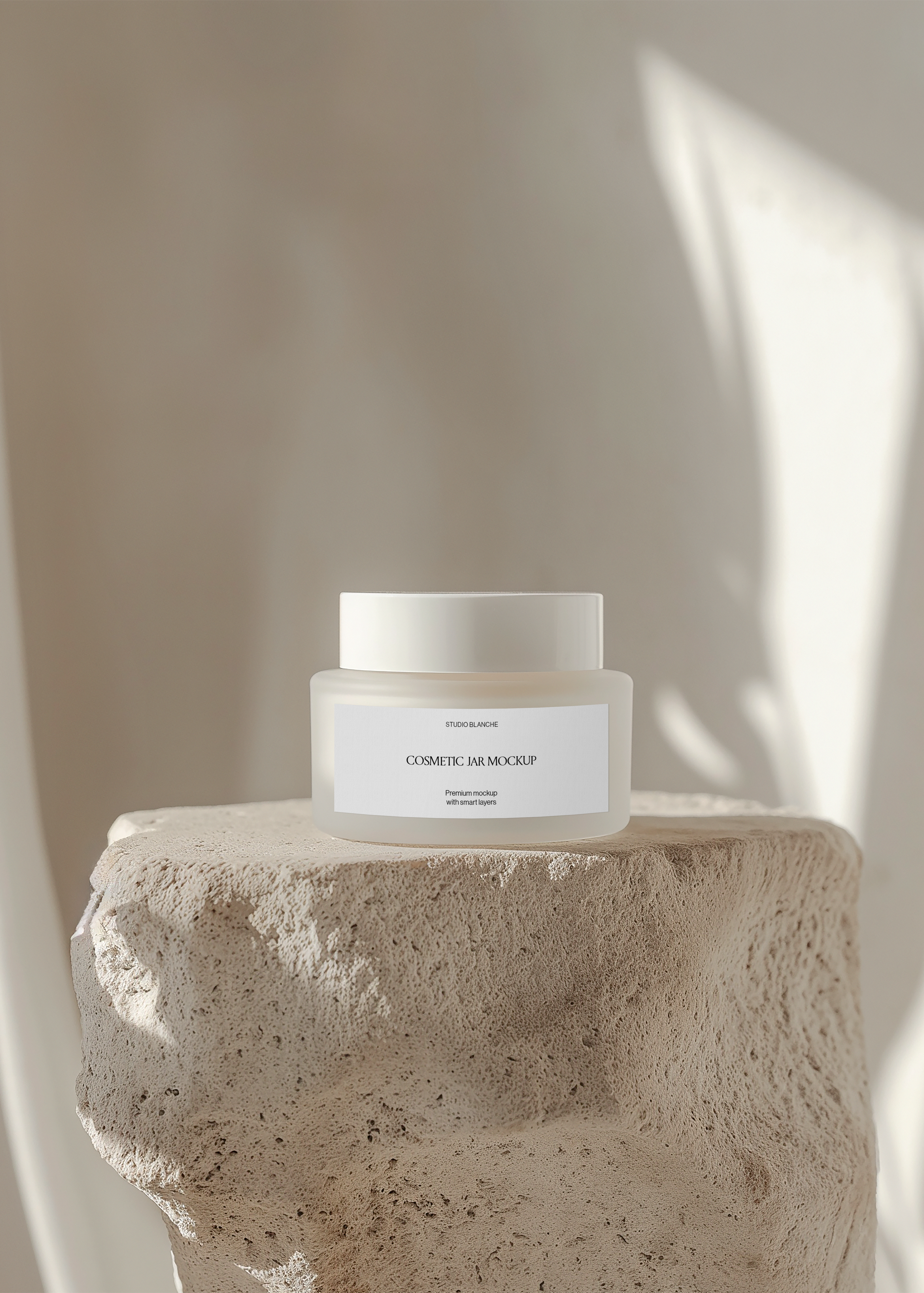 Frosted cosmetic cream jar mockup on textured travertine block with diagonal sunlight across warm plaster wall