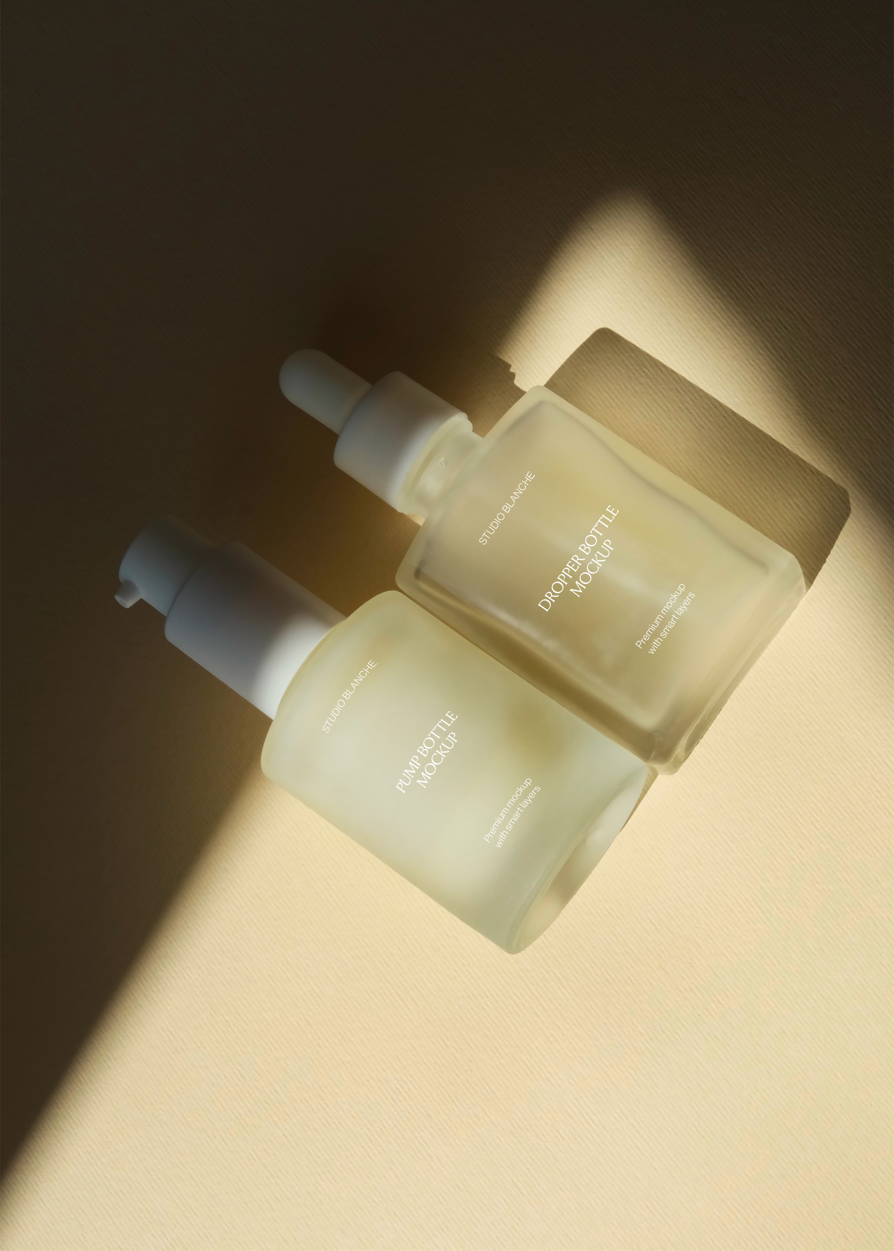 Pump bottle and dropper bottle mockup pair overlapping closely, warm directional light across matching labels