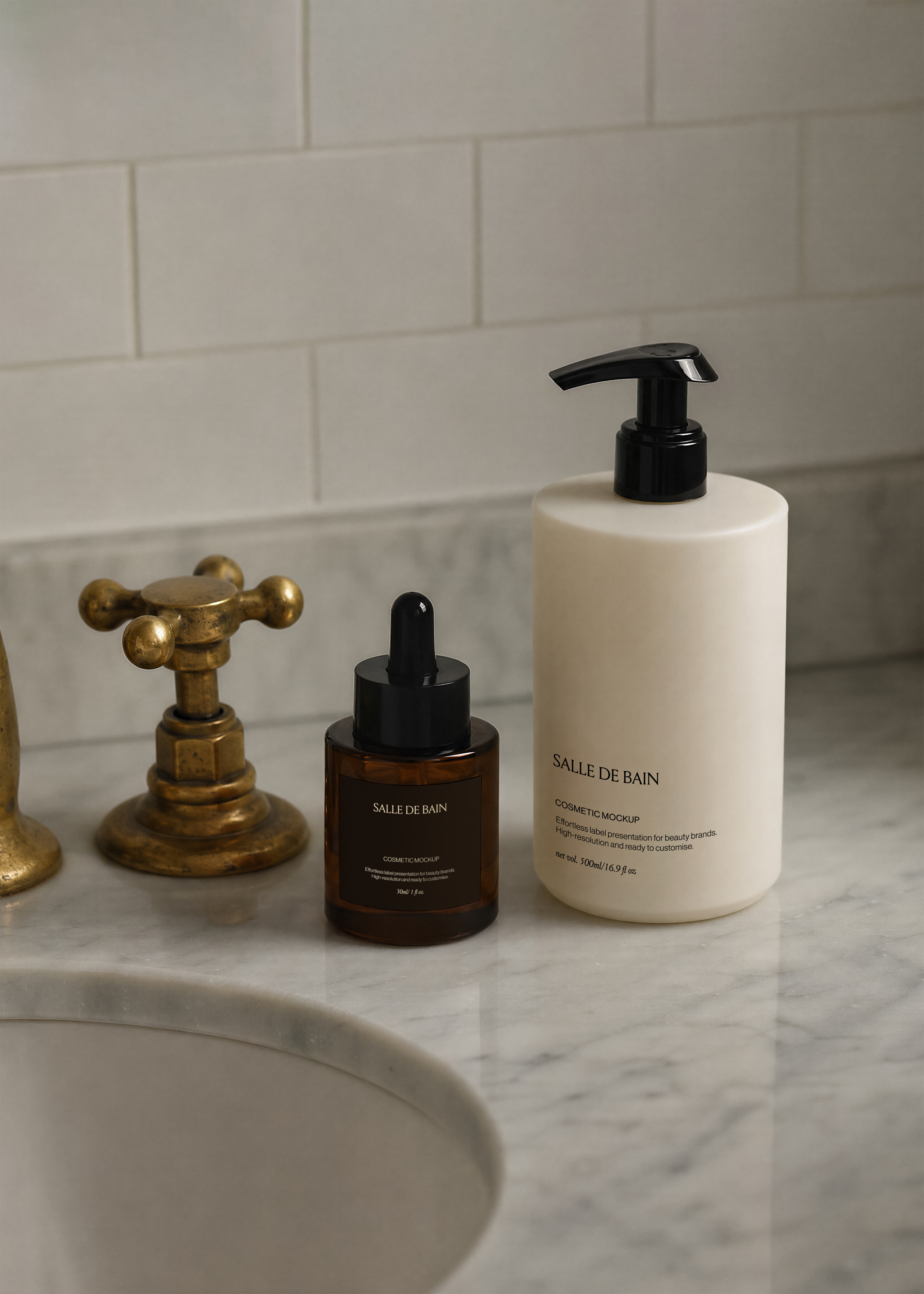 Amber dropper bottle and white pump bottle mockup on marble washstand beside aged brass tap, minimal editorial bathroom scene