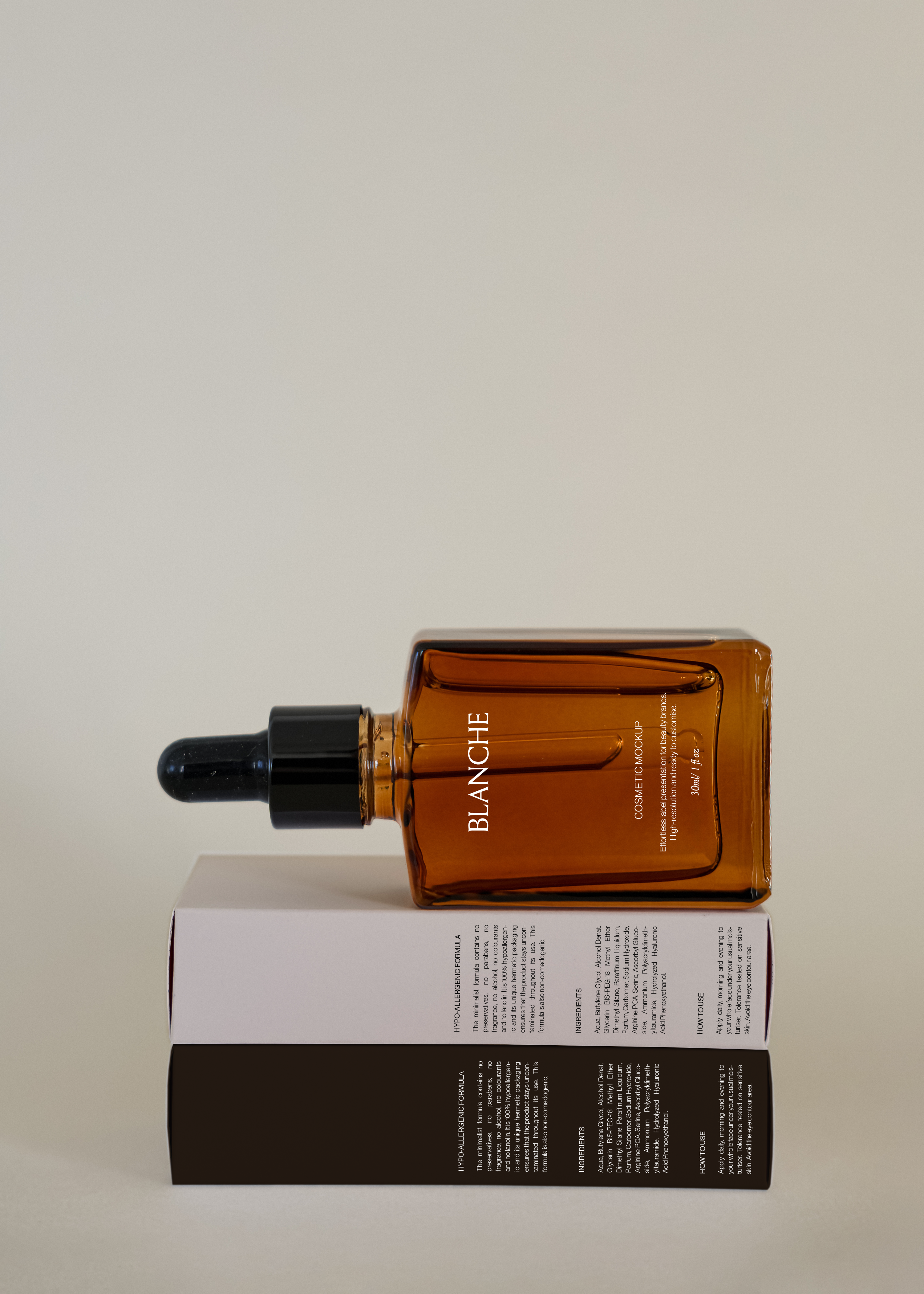 Amber glass dropper bottle mockup lying on stacked white and dark cosmetic boxes against warm neutral backdrop