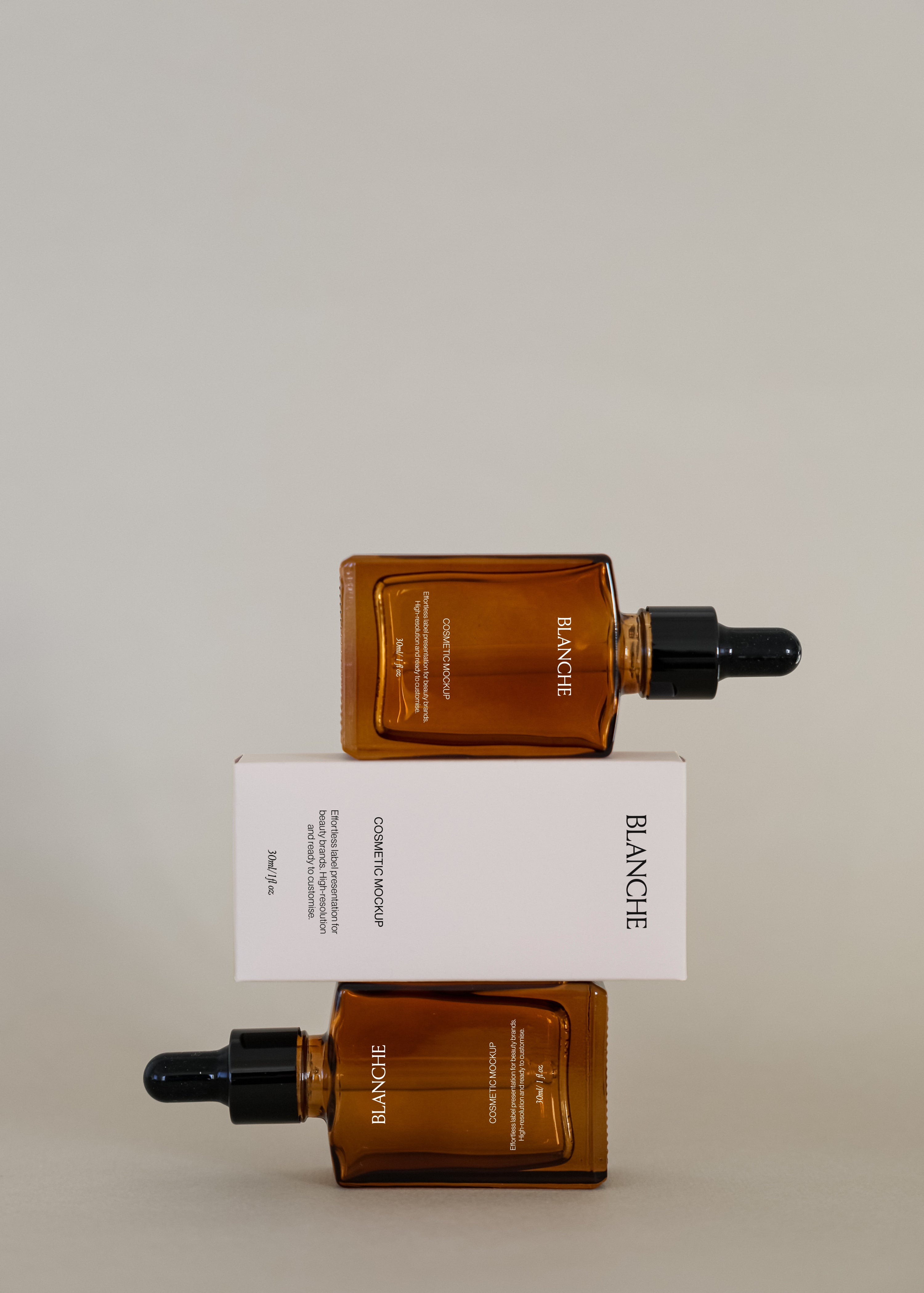 Two amber glass dropper bottle mockups stacked above and below a white cosmetic box against neutral studio backdrop