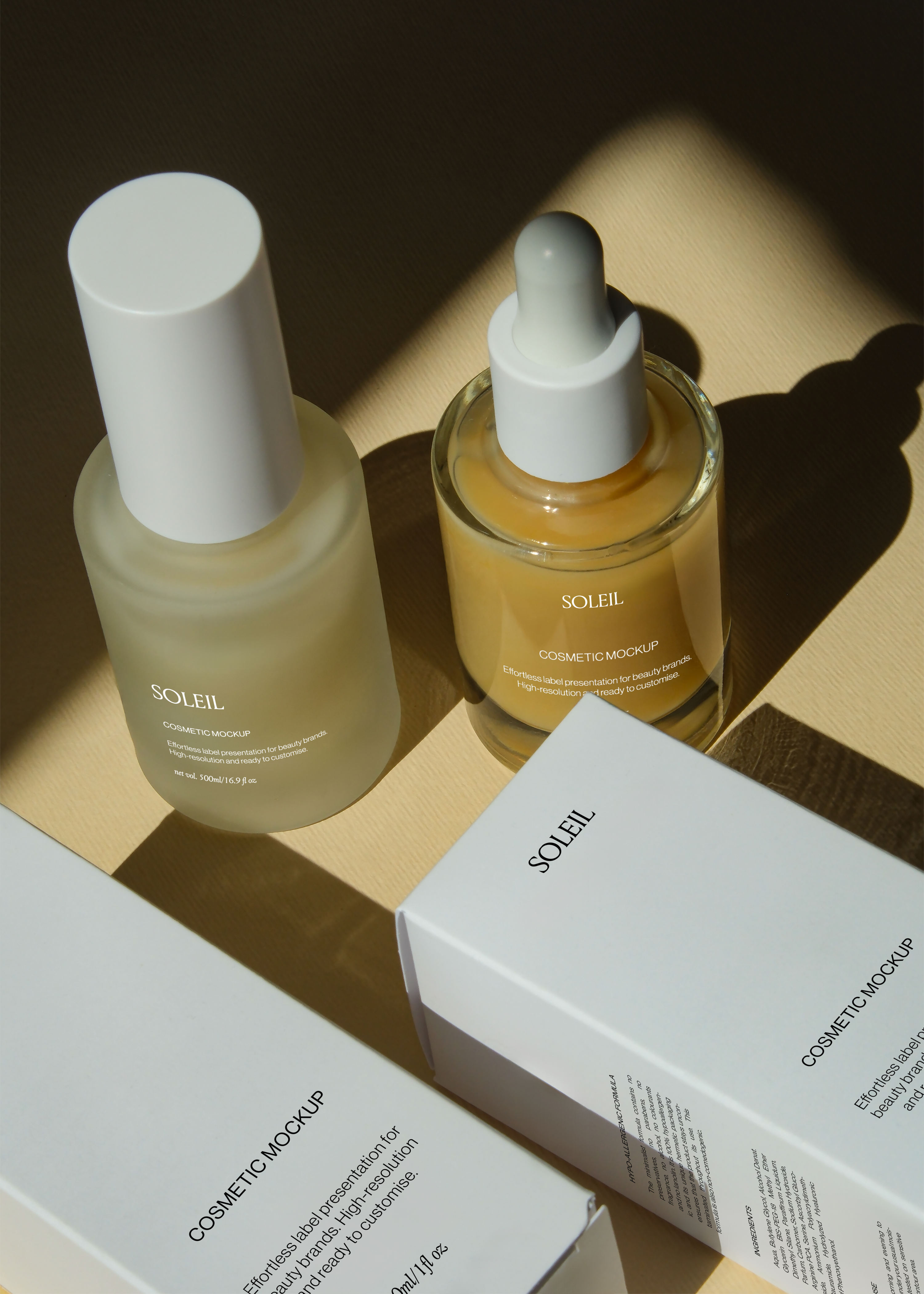 Overhead view of amber dropper bottle, frosted pump bottle, and cosmetic boxes arranged on tan surface with raking light