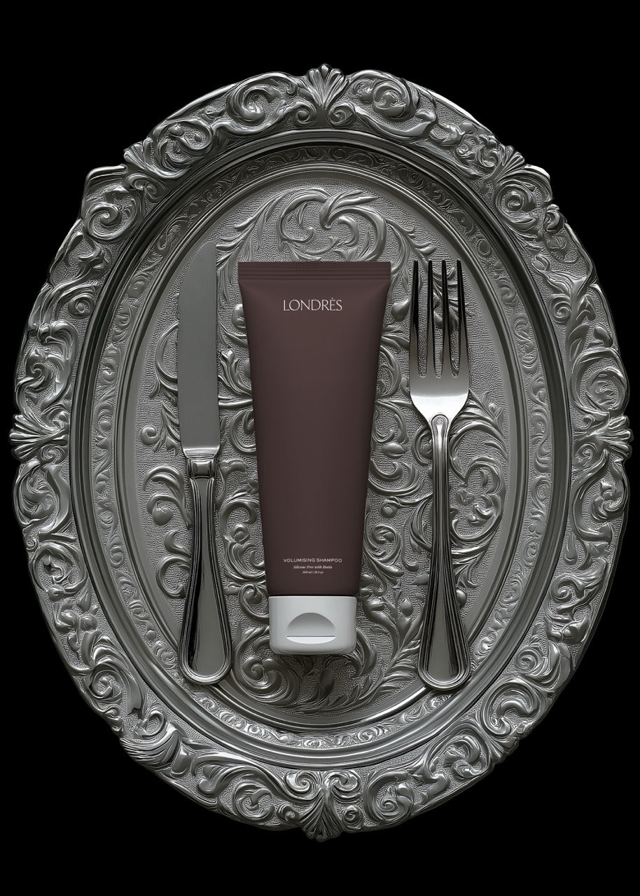 Skincare product on a decorative silver platter with a fork and knife.