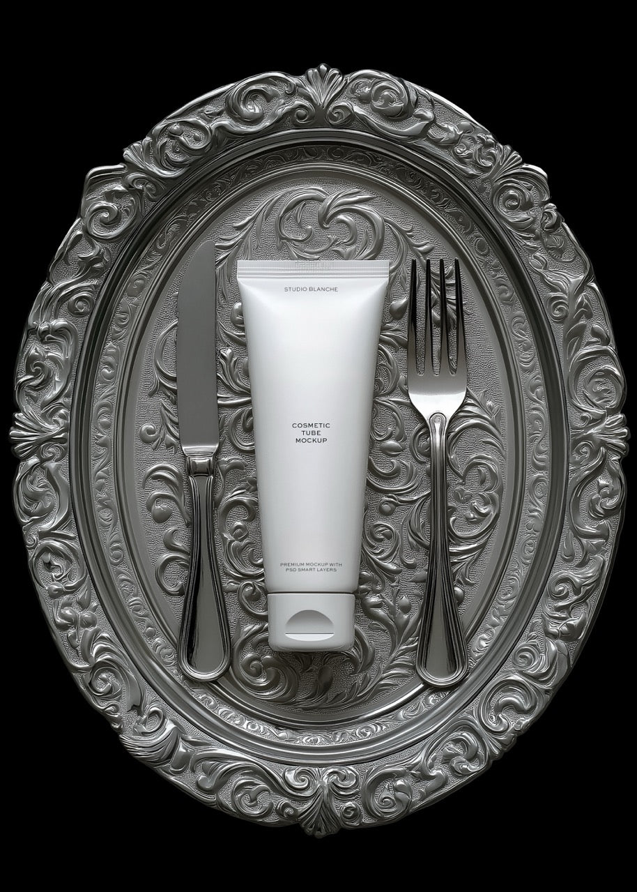 Tube of cream on a decorative silver plate with a fork and knife