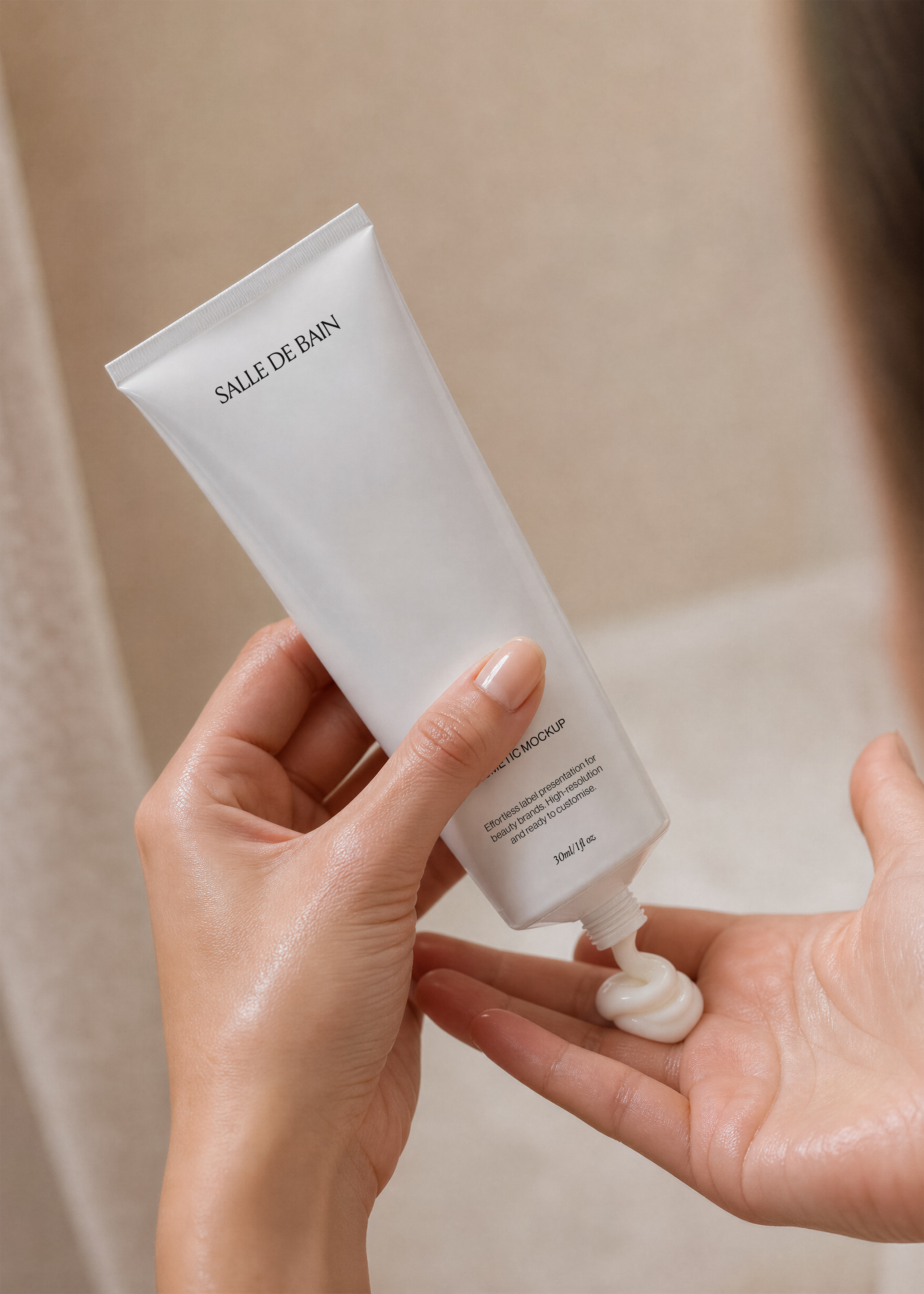 White cosmetic tube mockup squeezed into an open palm dispensing cream, warm tiled bathroom backdrop