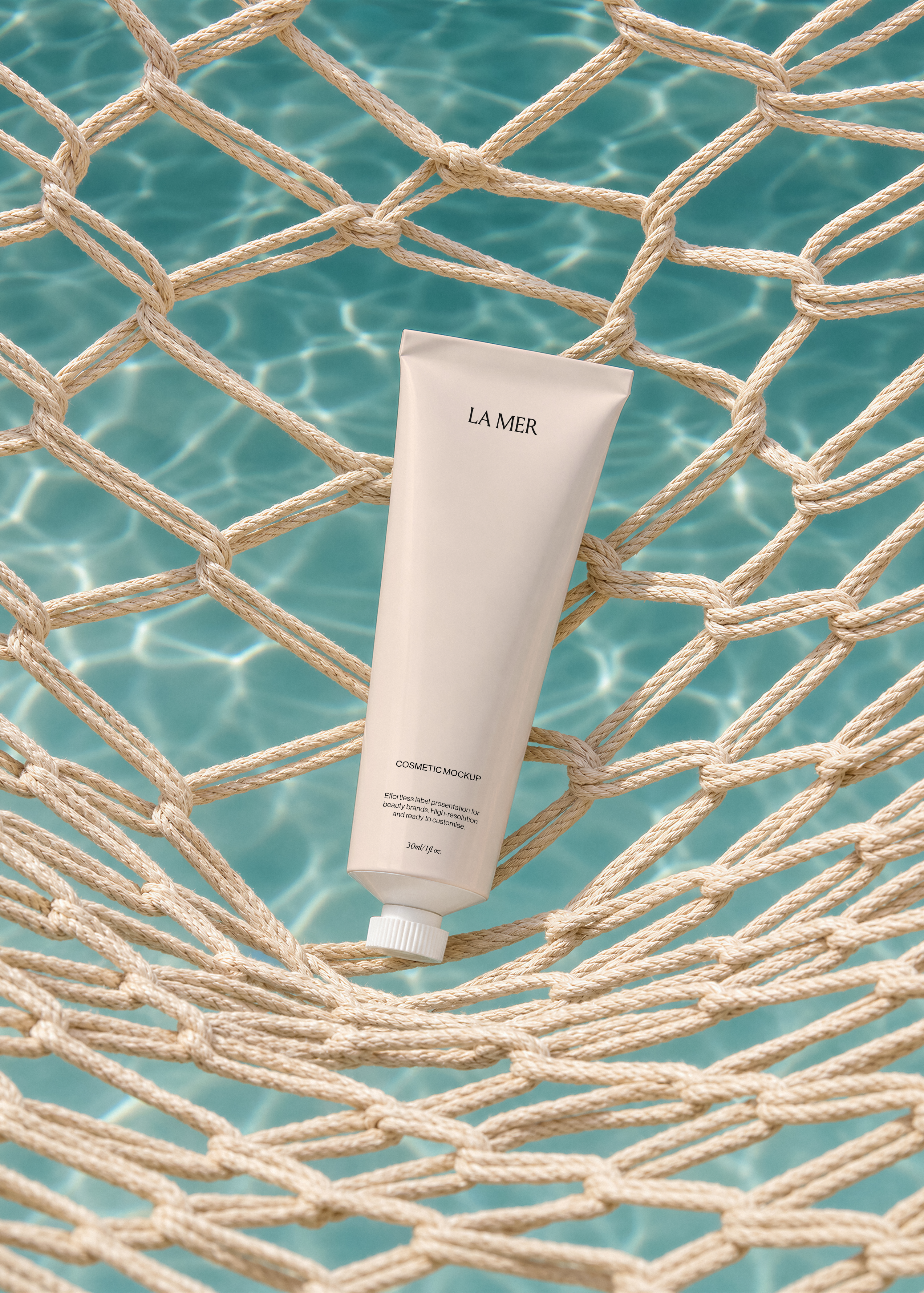Close view of a white cosmetic tube label held in a knotted rope net above rippling blue pool water, poolside scene
