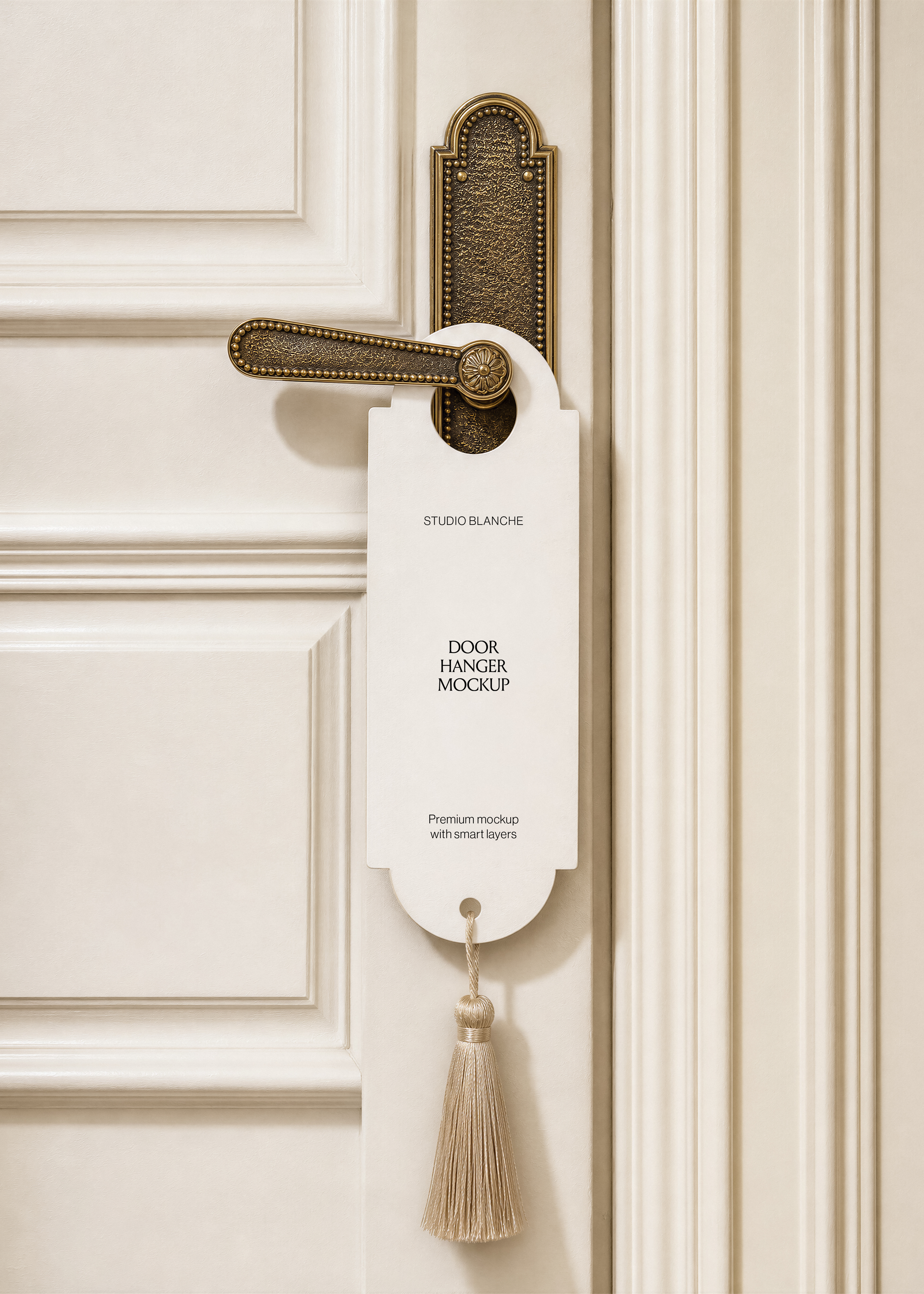 Blank door hanger mockup with tassel cord on brass handle plate, cream panelled hotel door background