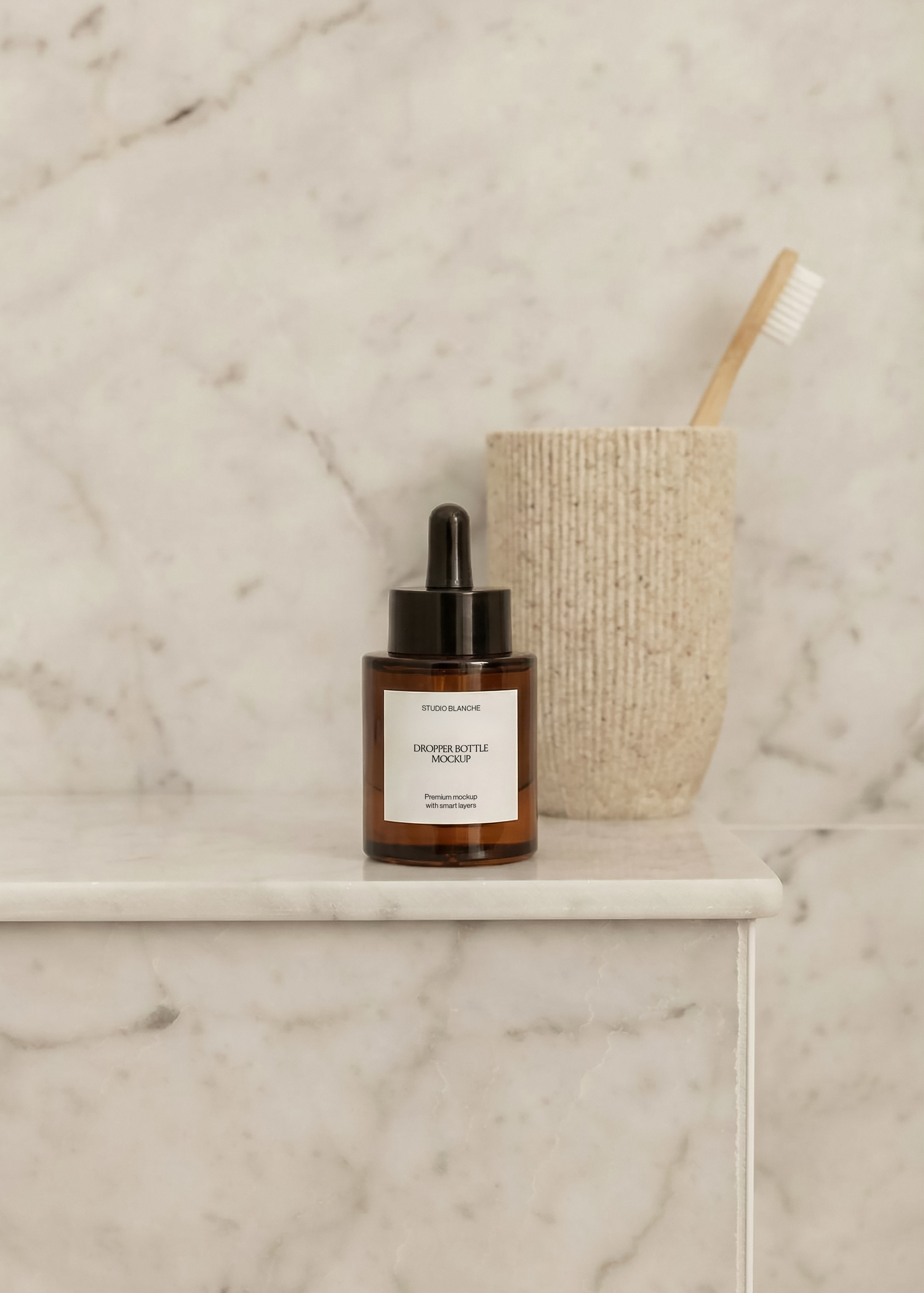 Dropper bottle mockup on marble bathroom ledge with bamboo toothbrush in a textured beige cup, soft daylight