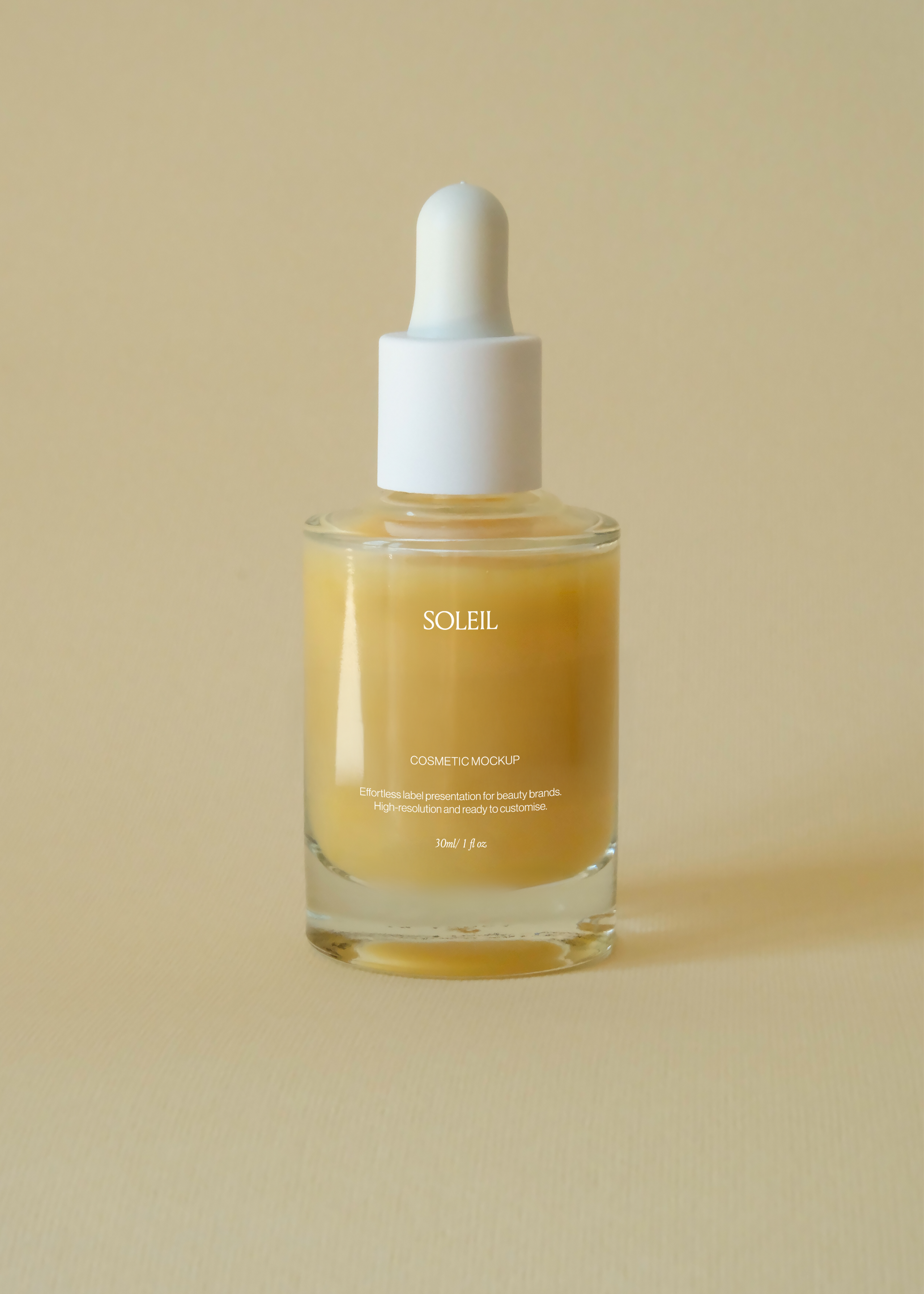 Amber glass dropper bottle with white pipette cap standing upright on plain warm beige background, front-facing view