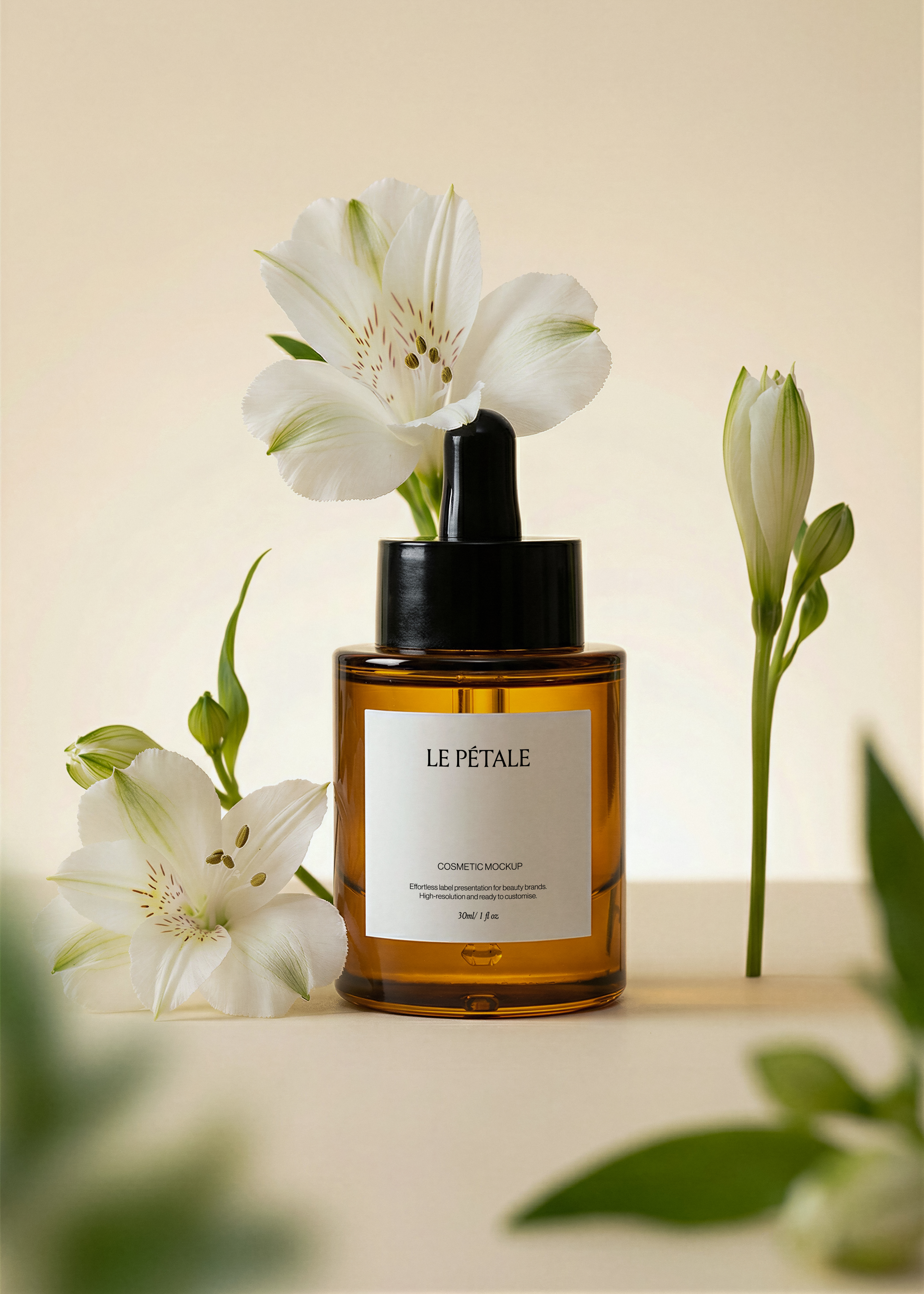 Amber dropper bottle mockup with label, white alstroemeria blooms and bud stem, blurred green foreground, warm sand backdrop