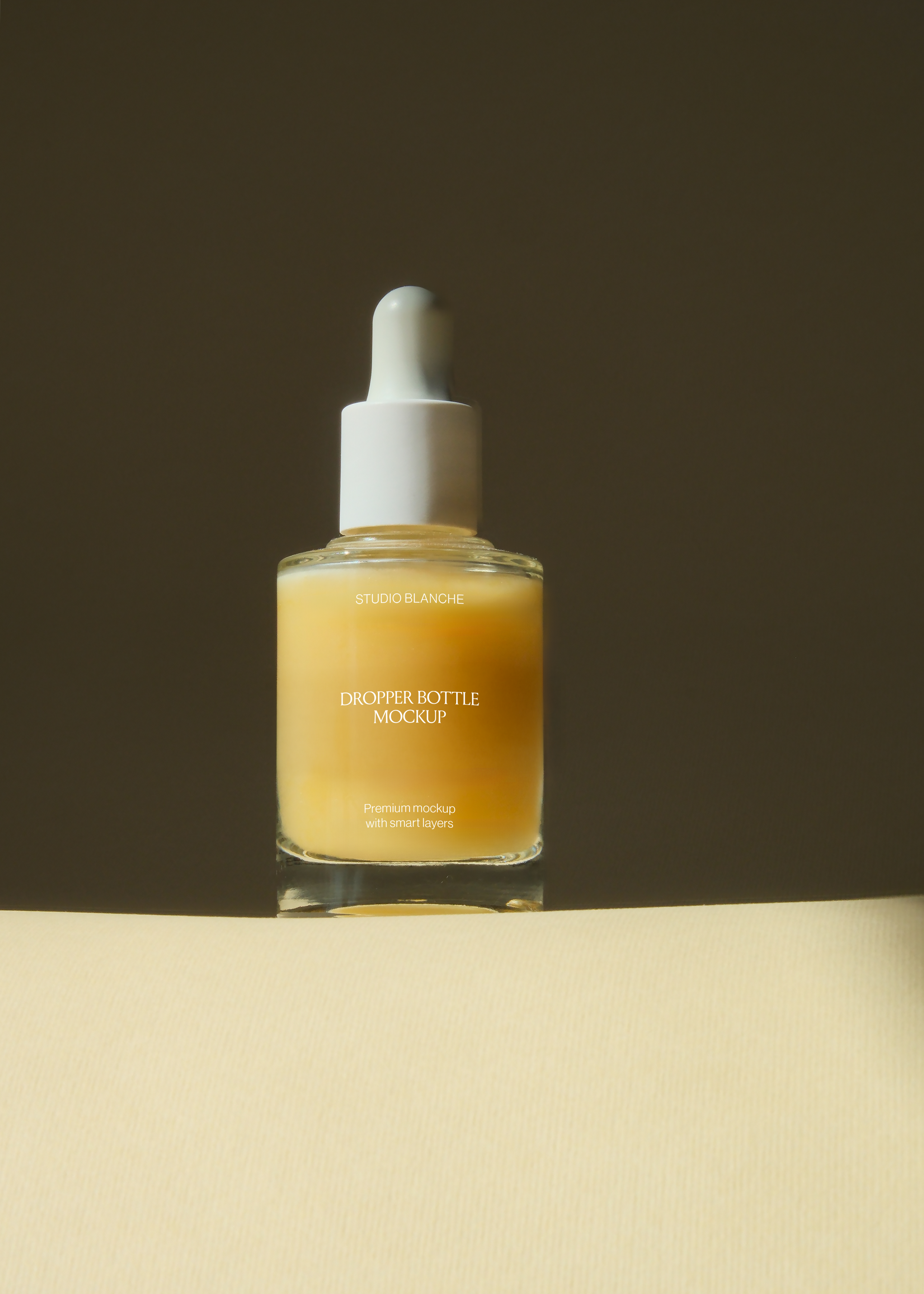 Straight-on view of glass dropper bottle with white pipette cap, warm light meeting dark background edge
