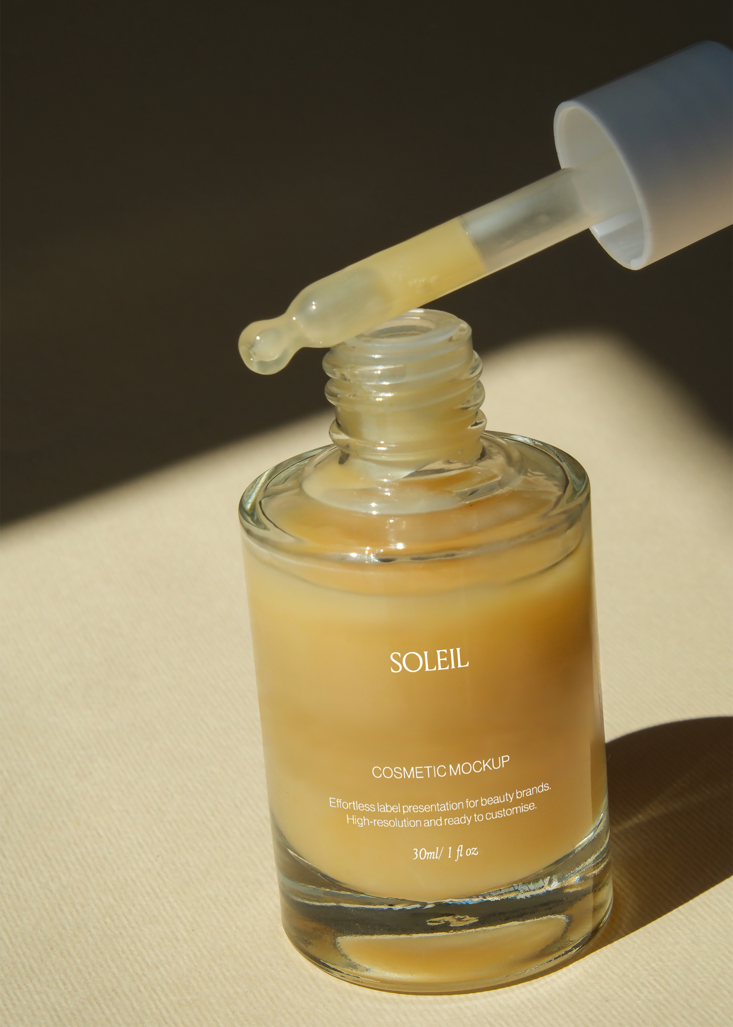 Glass dropper bottle mockup with pipette lifted, amber serum drop visible, open white cap, warm sunlit tabletop scene
