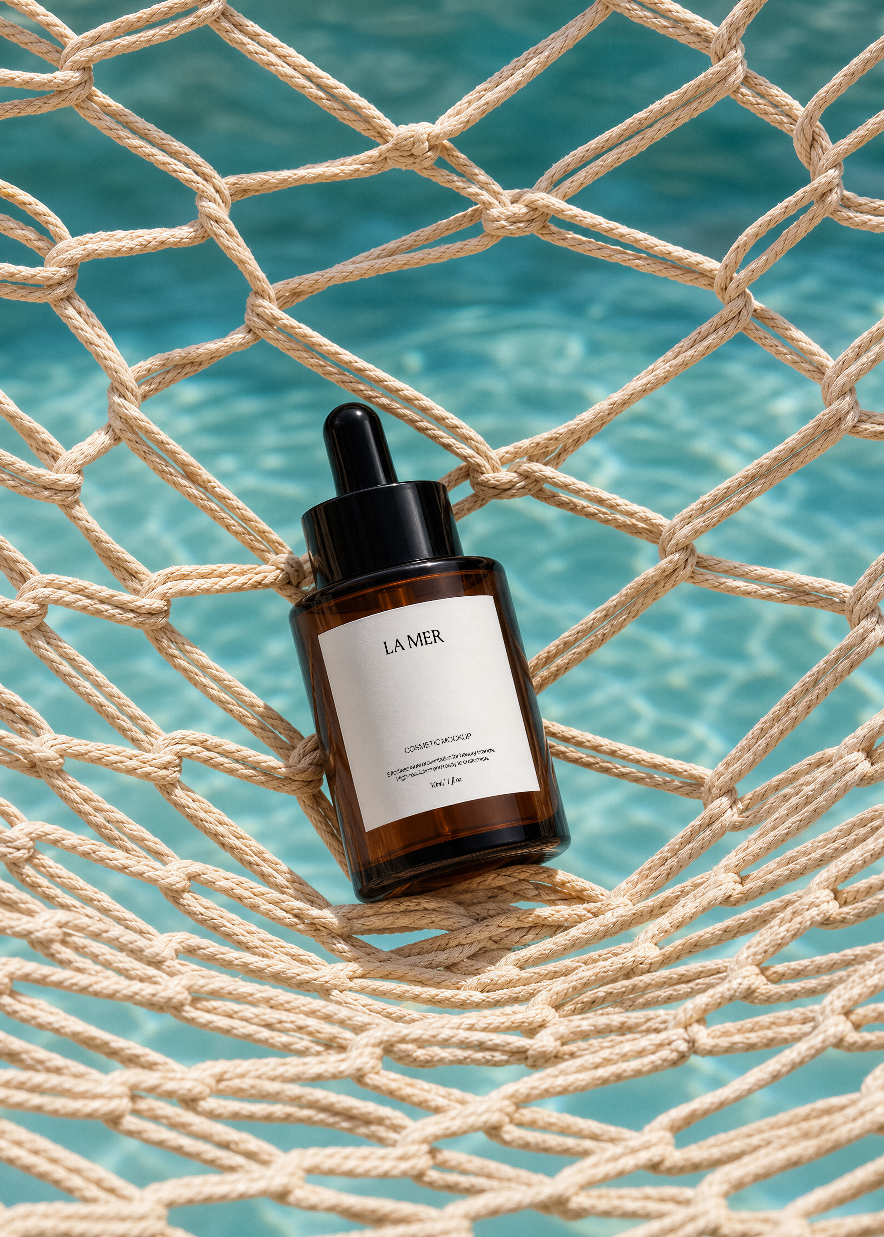 Amber dropper bottle mockup resting on a beige rope net stretched over a turquoise swimming pool, coastal styling