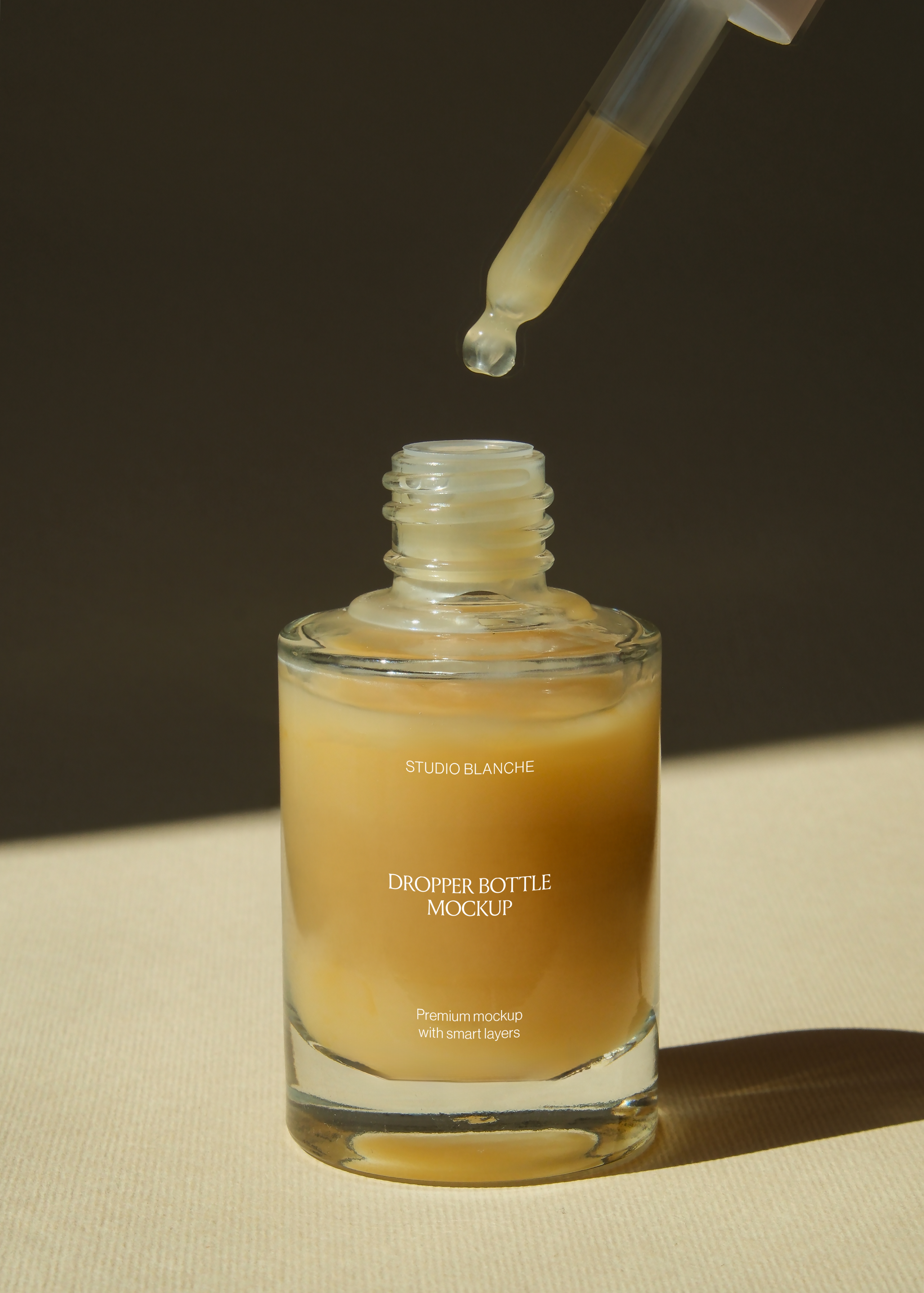 Close detail of glass dropper bottle threaded opening with pipette raised, single droplet caught mid-fall
