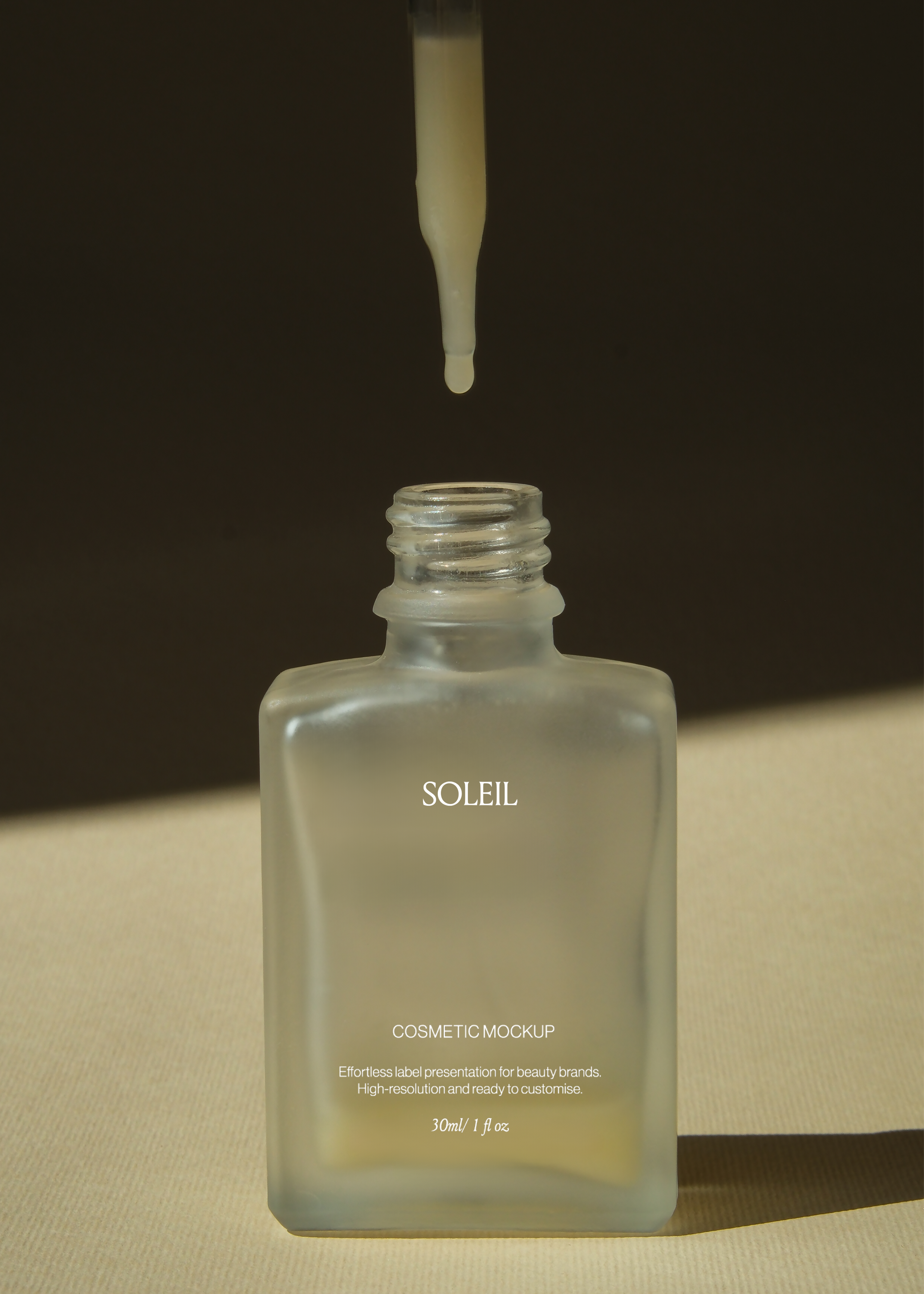 Frosted glass dropper bottle mockup with serum drop suspended above open neck, dark backdrop, warm side light