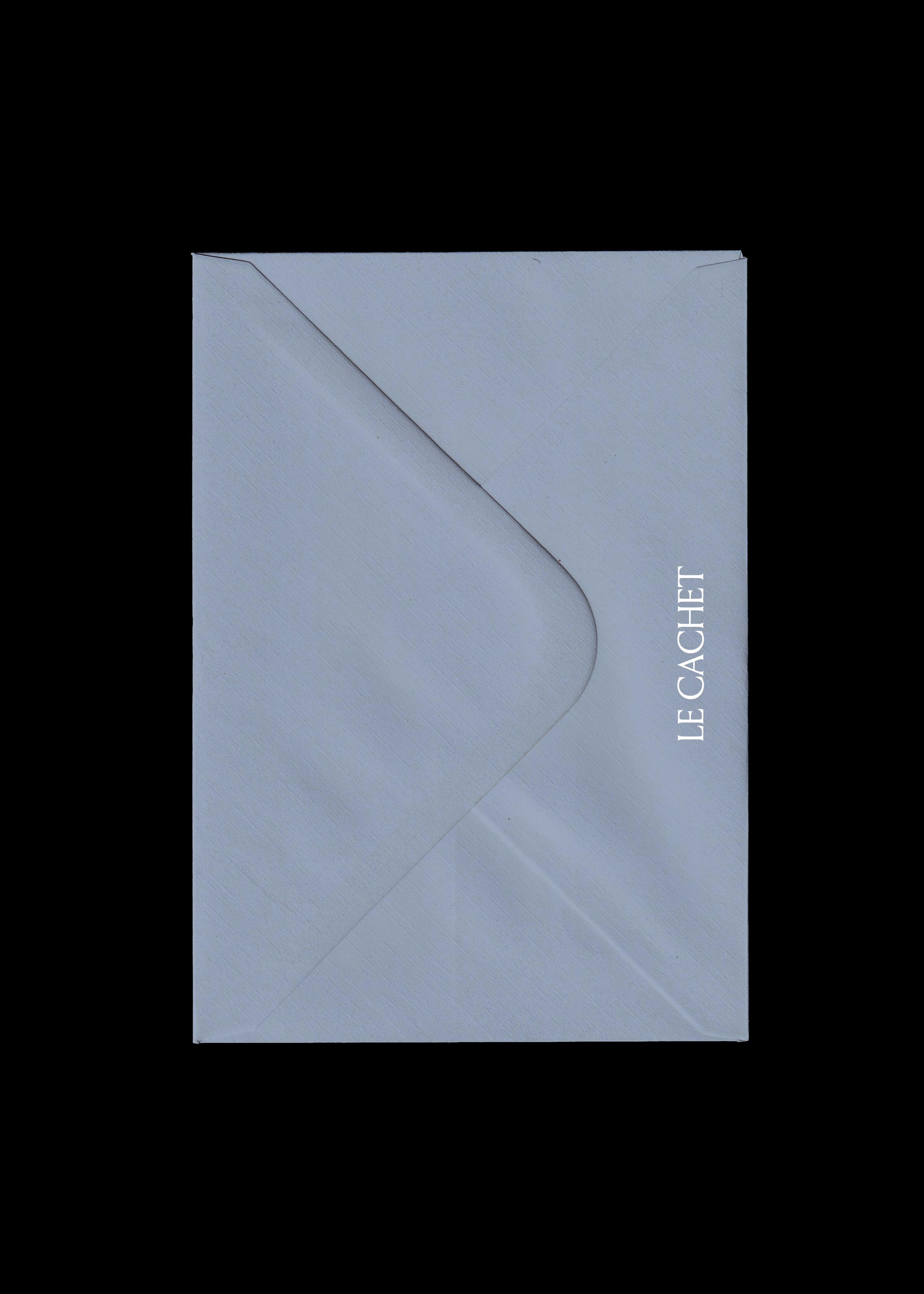 Pale blue-grey envelope mockup scanned flat on black, textured laid paper with vertical white serif wordmark