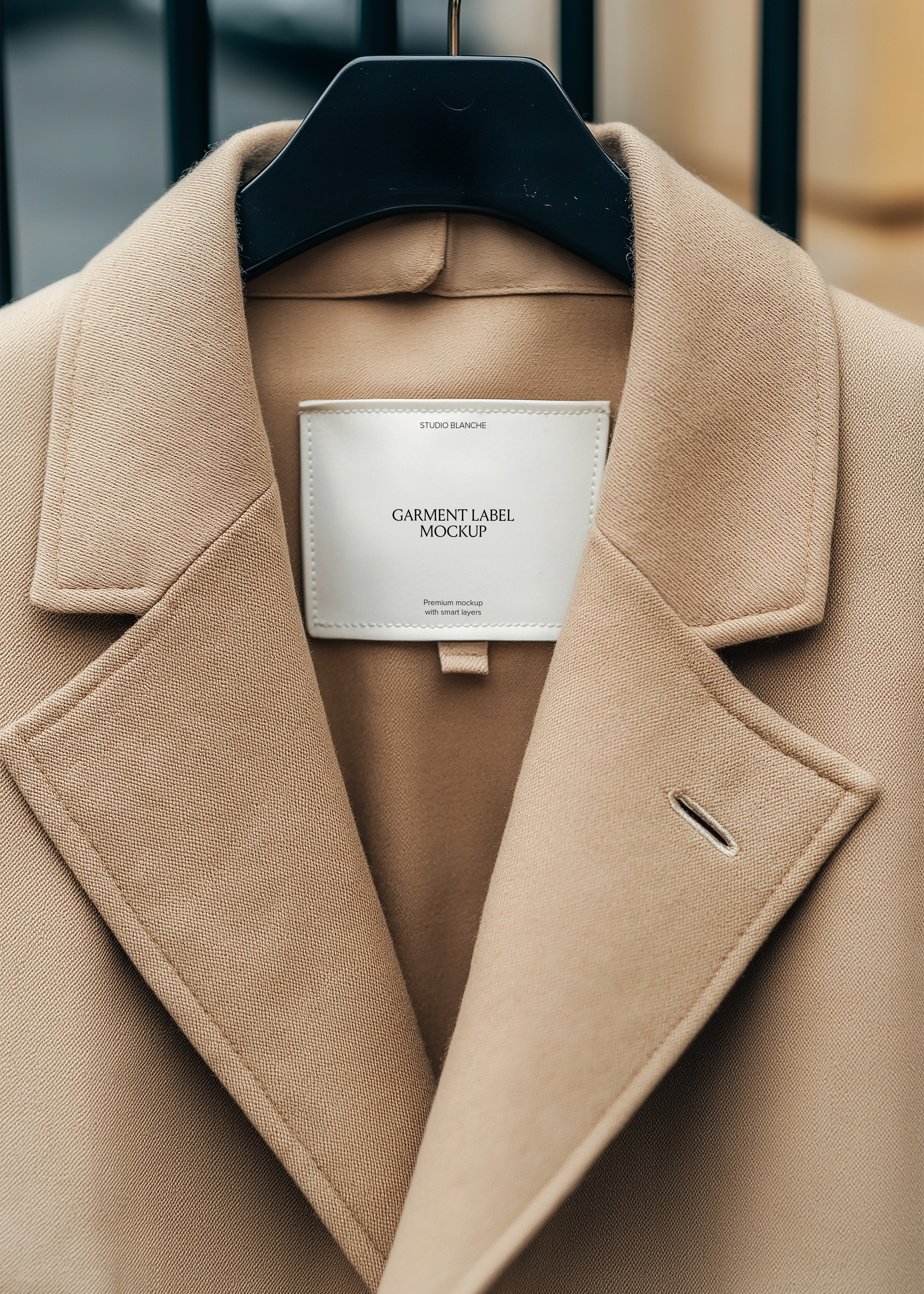 White woven garment label mockup on structured camel coat collar, minimal text layout, neutral editorial styling