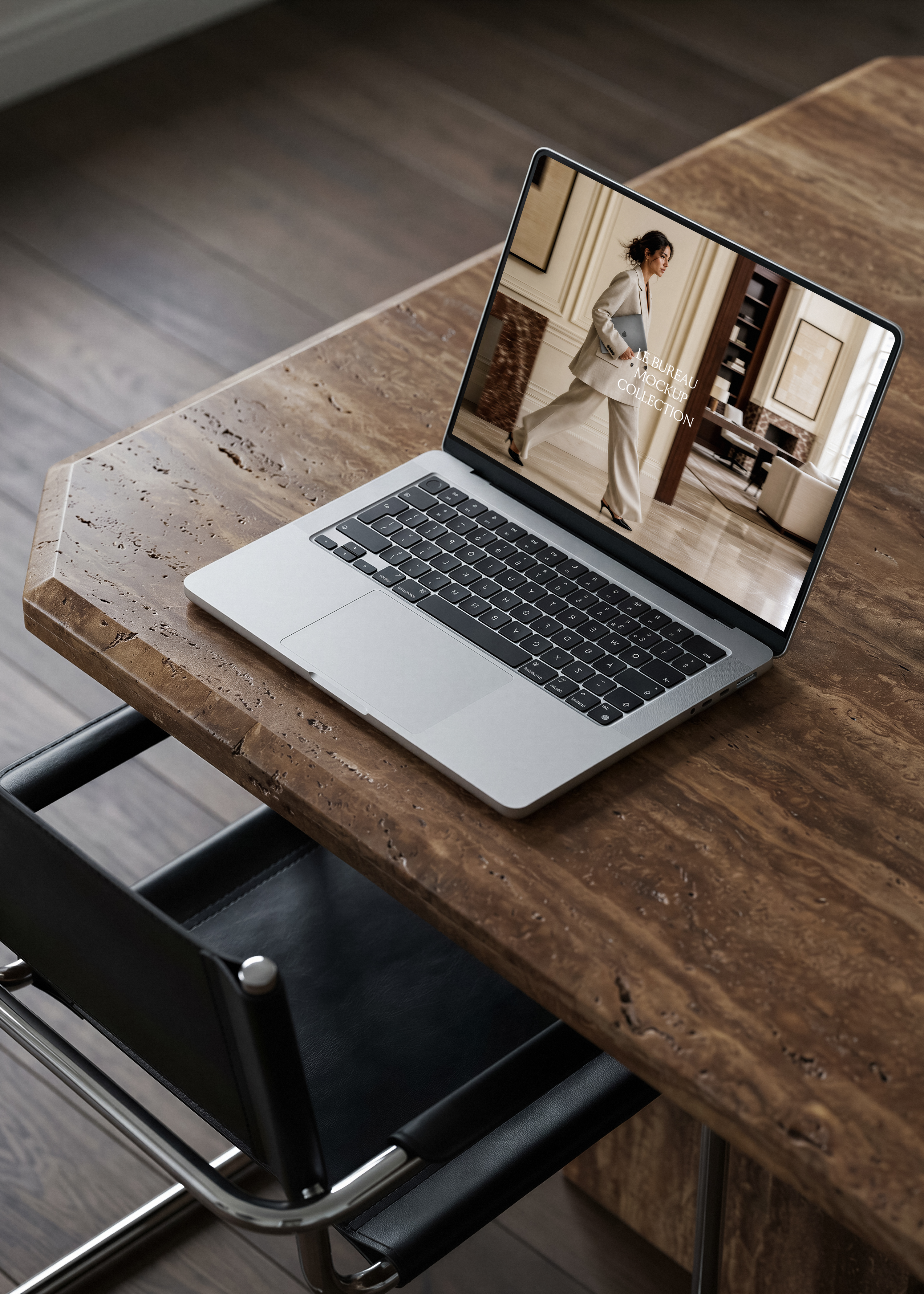 MacBook mockup on travertine desk displaying Le Bureau editorial image, warm architectural office scene